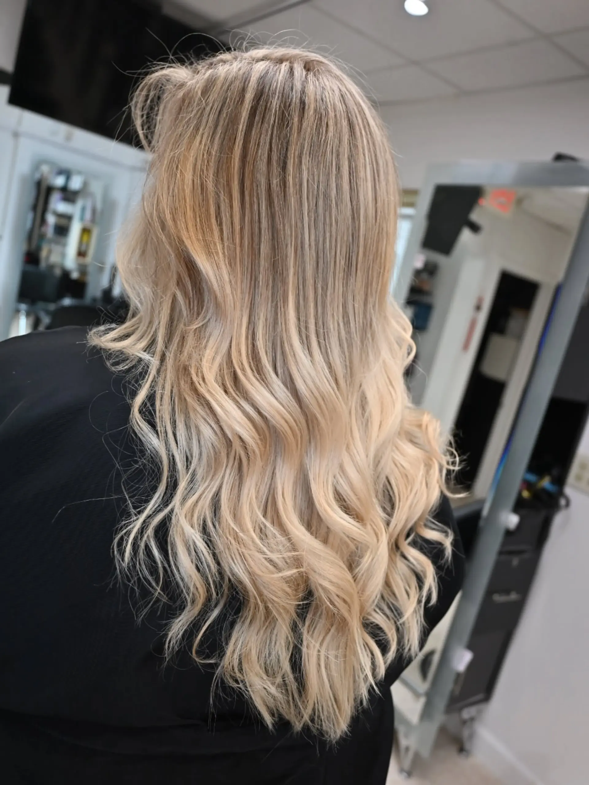 Long wavy hair styled with dimensional blonde highlights and soft lowlights. 1