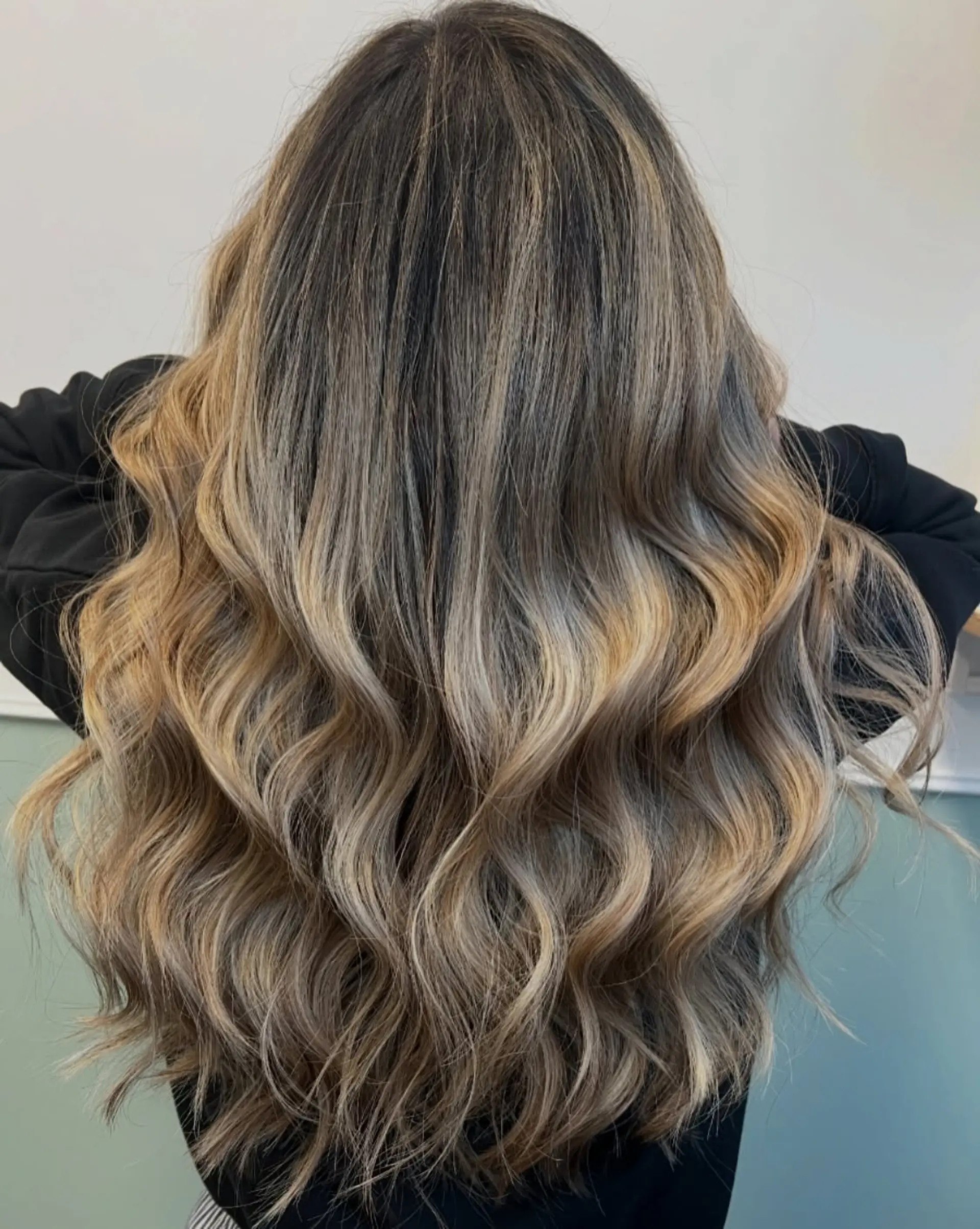 Long hair featuring a seamless dimensional blonde balayage styled in soft, loose waves. 1