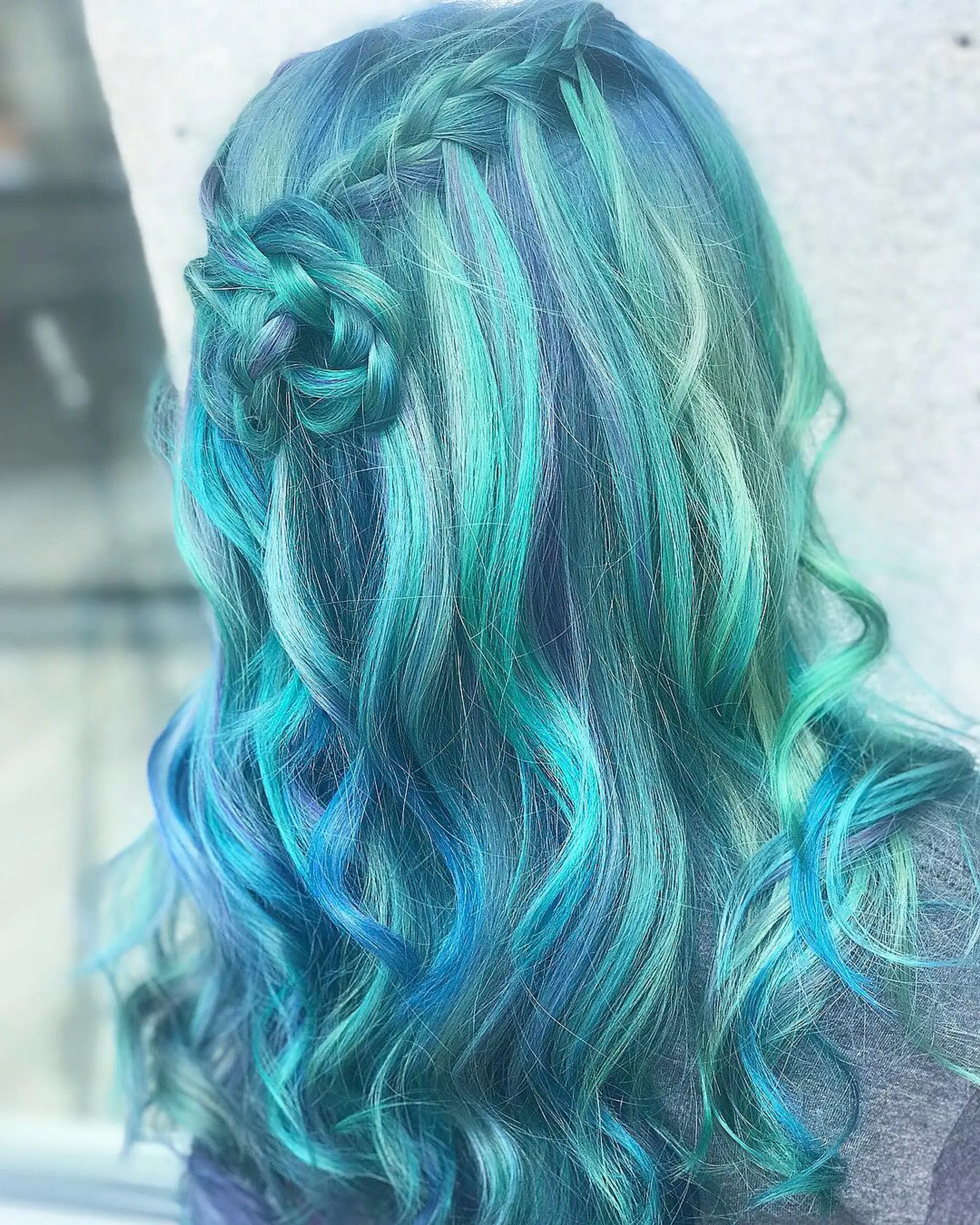 Long, wavy hair in teal, blue, and aqua hues with a braided crown transitioning into loose waves. 1