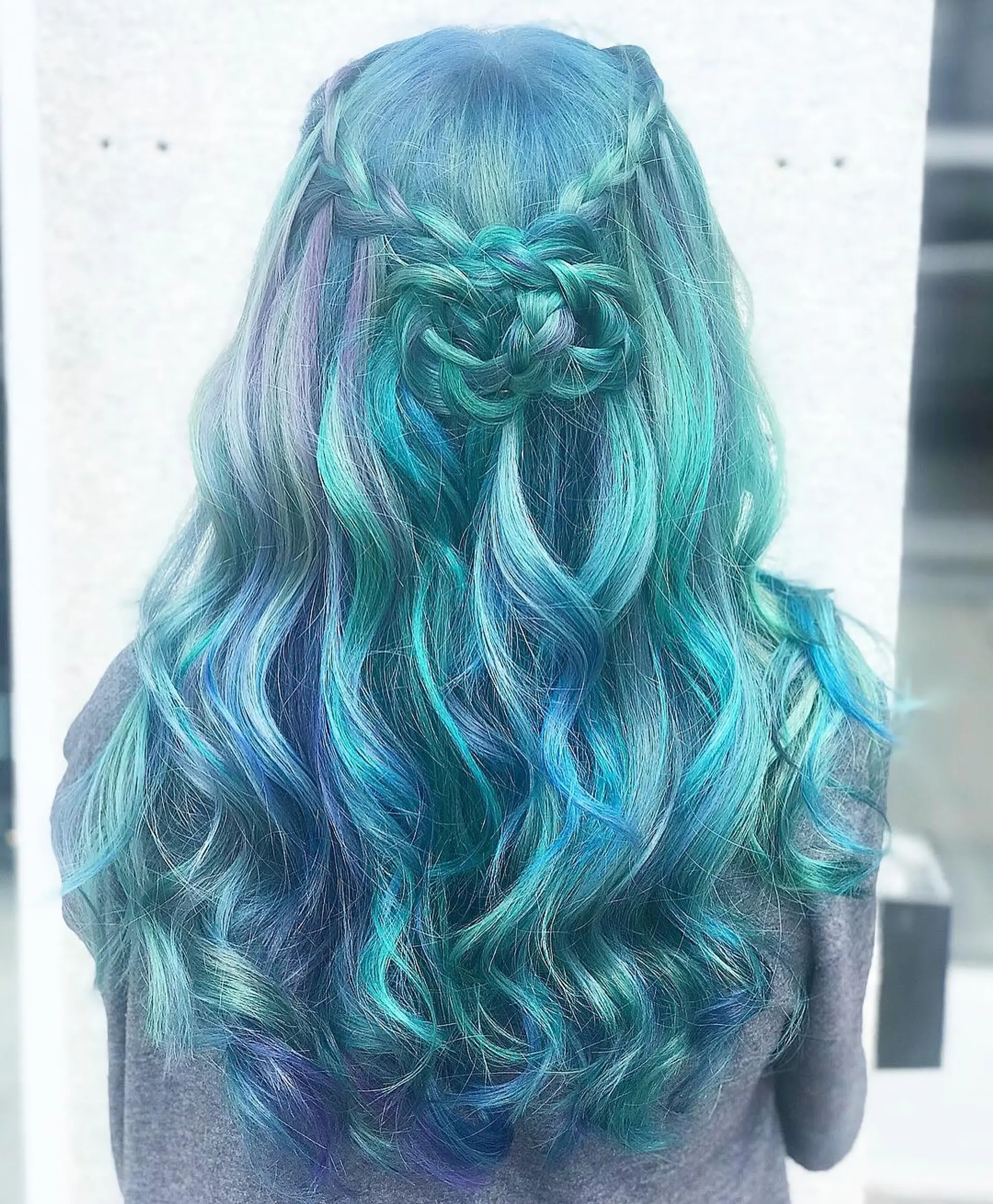 Long, wavy hair in teal, blue, and aqua hues with a braided crown transitioning into loose waves. 2