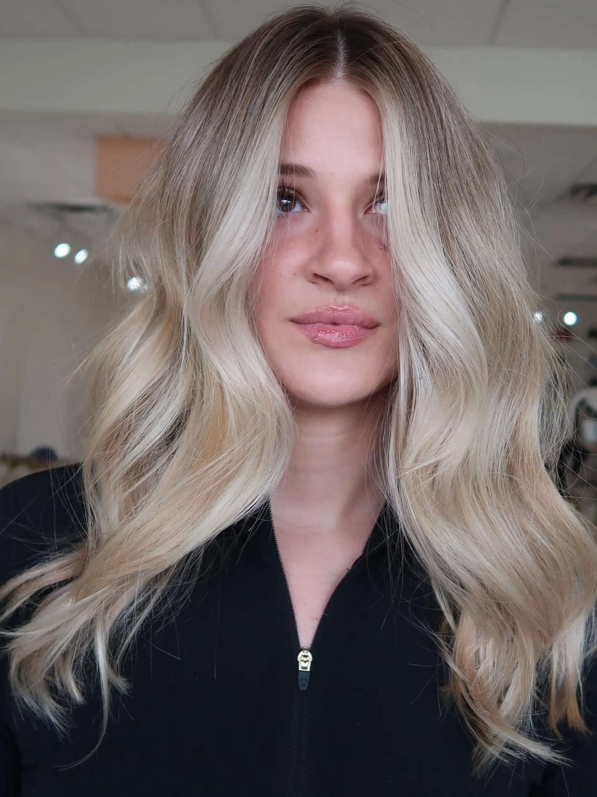 Long, dimensional lived-in blonde hair styled with soft, voluminous waves and bright face-framing pieces. 1