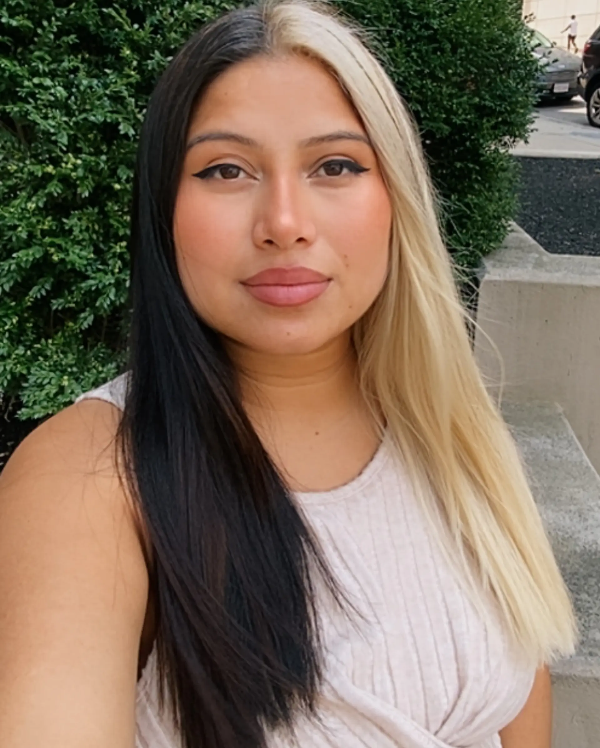 A bold split dye hairstyle featuring jet black on one side and light platinum blonde on the other, parted cleanly down the center. 1