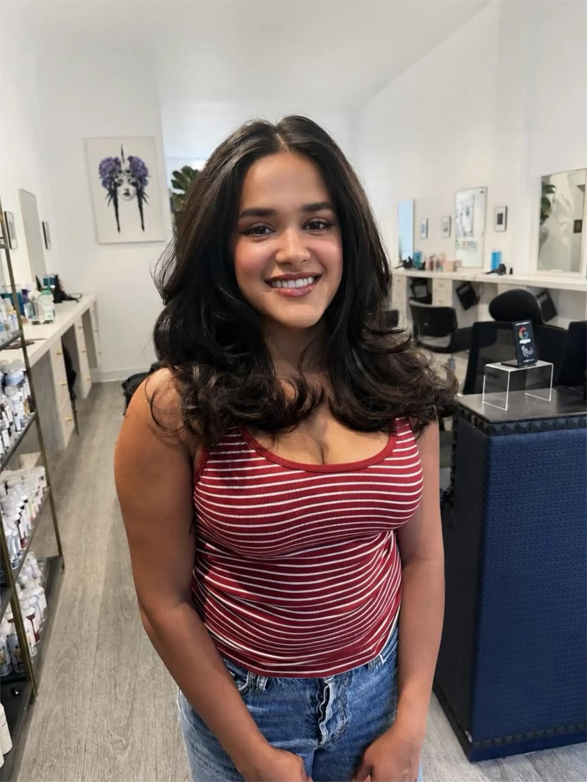 Voluminous medium-length layered hair styled into a bouncy blowout with curled ends and face-framing pieces. 1