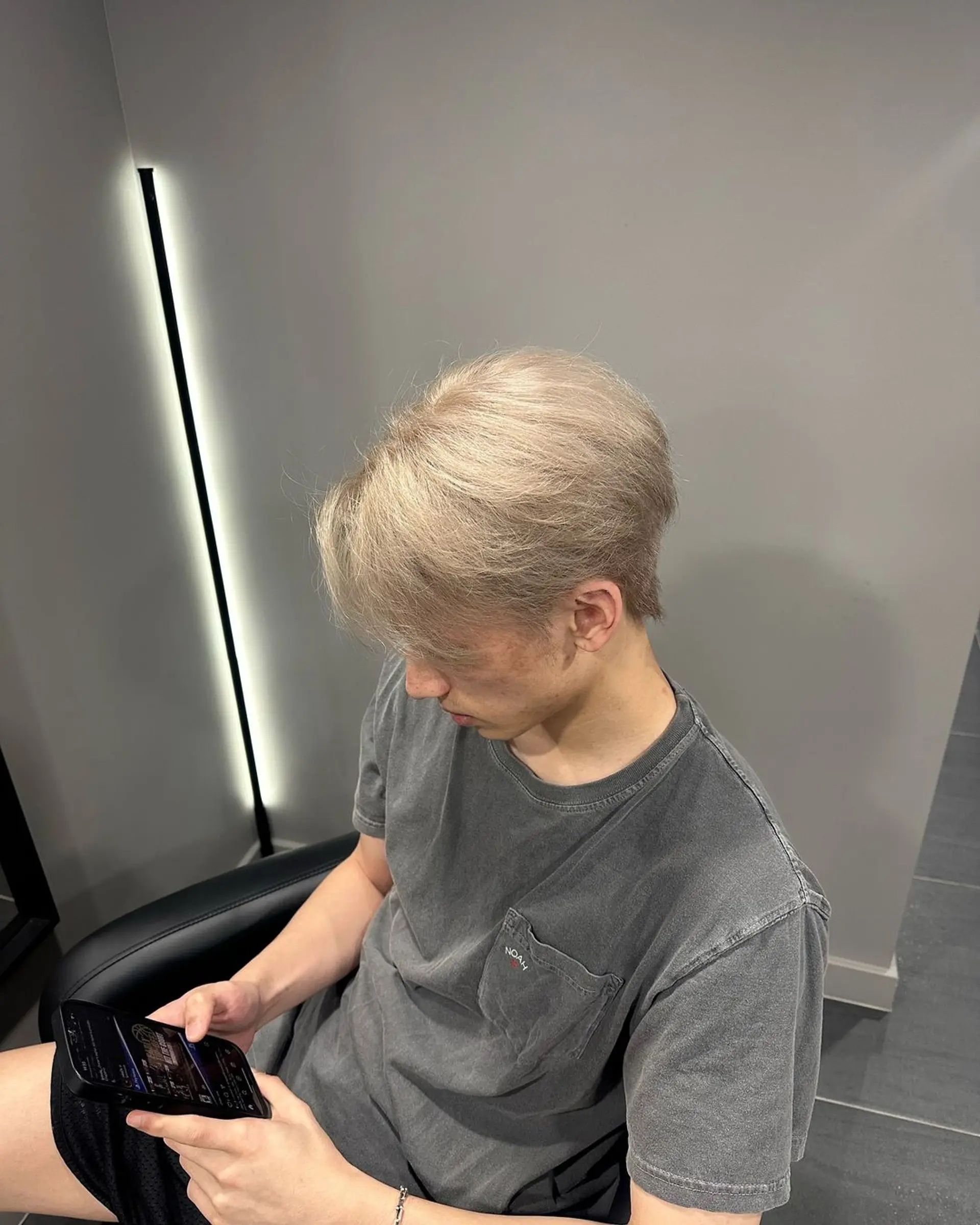 Medium-length, straight hair with a platinum blonde and silver tone, featuring curtain bangs, textured layers, and a tapered back. 2