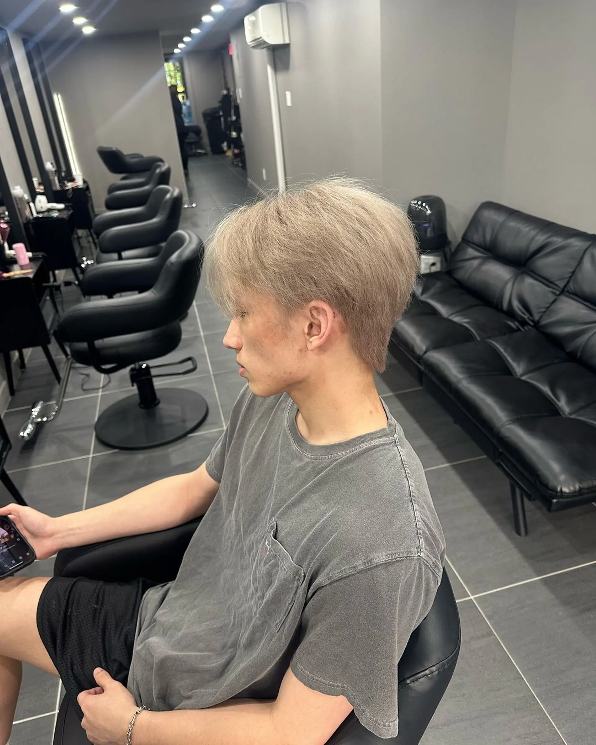 Medium-length, straight hair with a platinum blonde and silver tone, featuring curtain bangs, textured layers, and a tapered back. 1