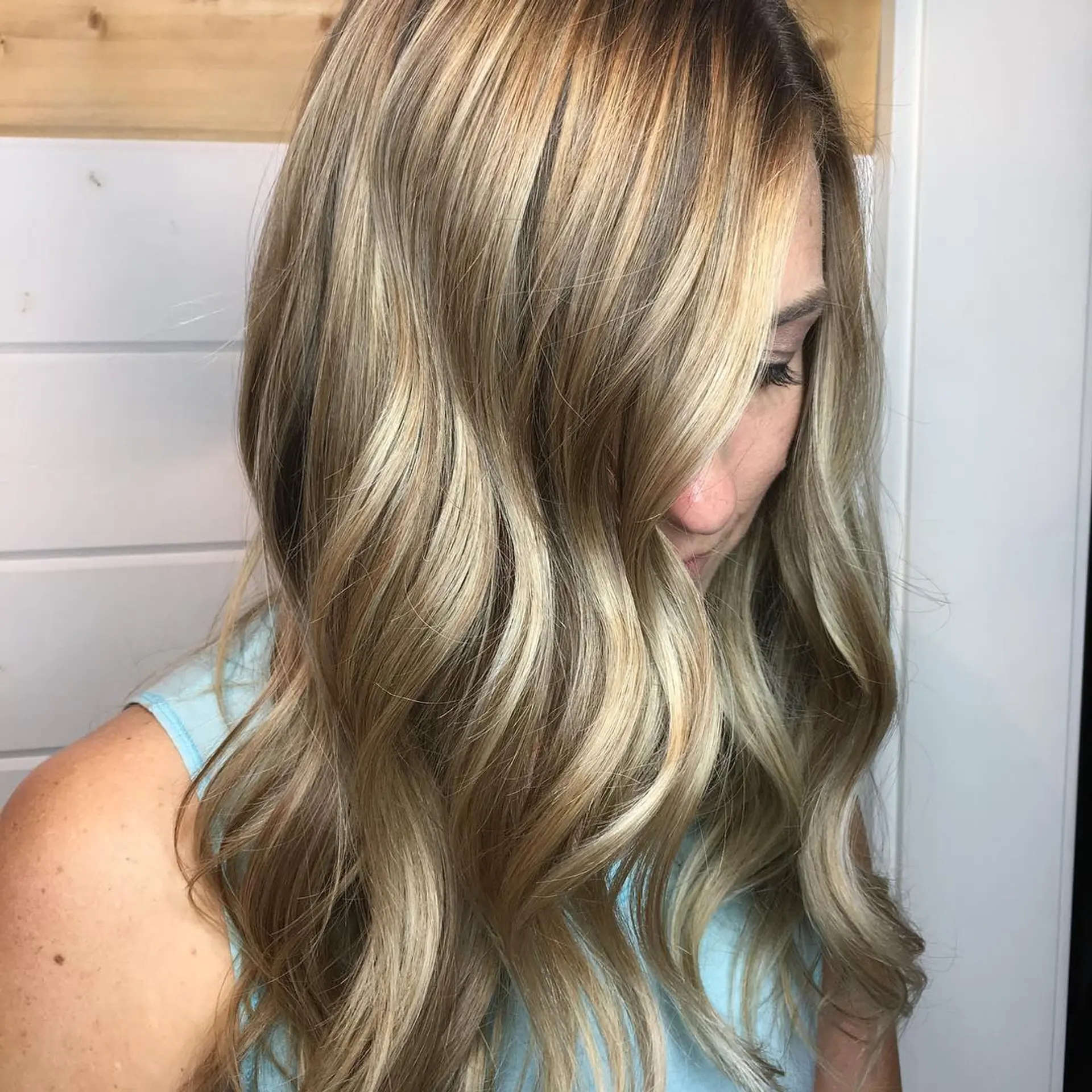 Long hair featuring a seamless blonde balayage styled in soft, flowing waves. 1