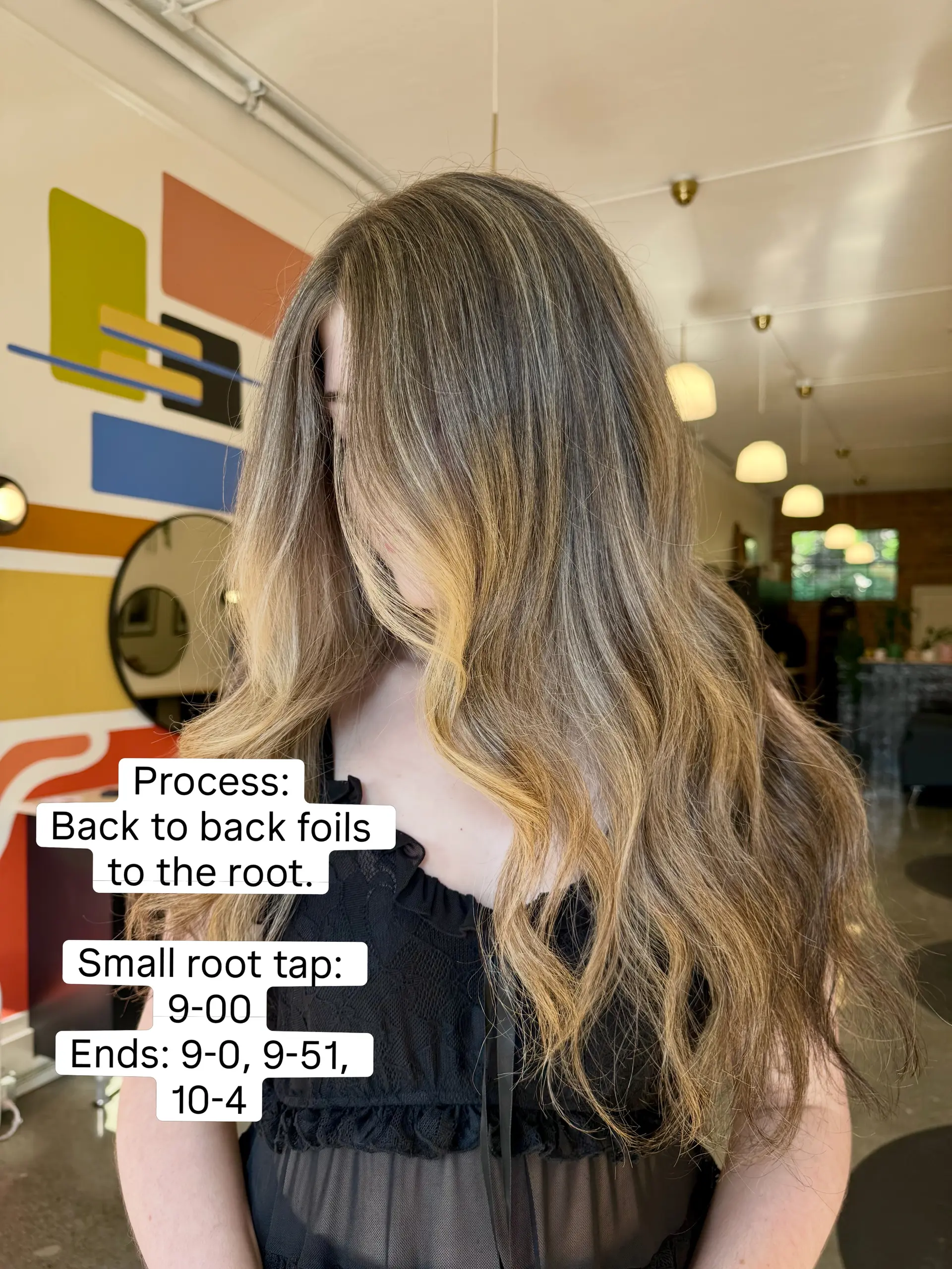 Long wavy golden blonde hair featuring seamless full foil highlights and soft dimensional waves. 1