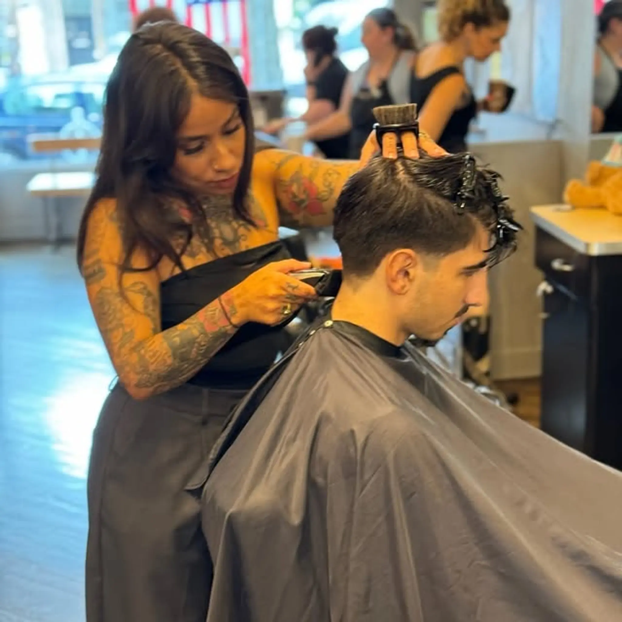 A short taper fade haircut with a side part.