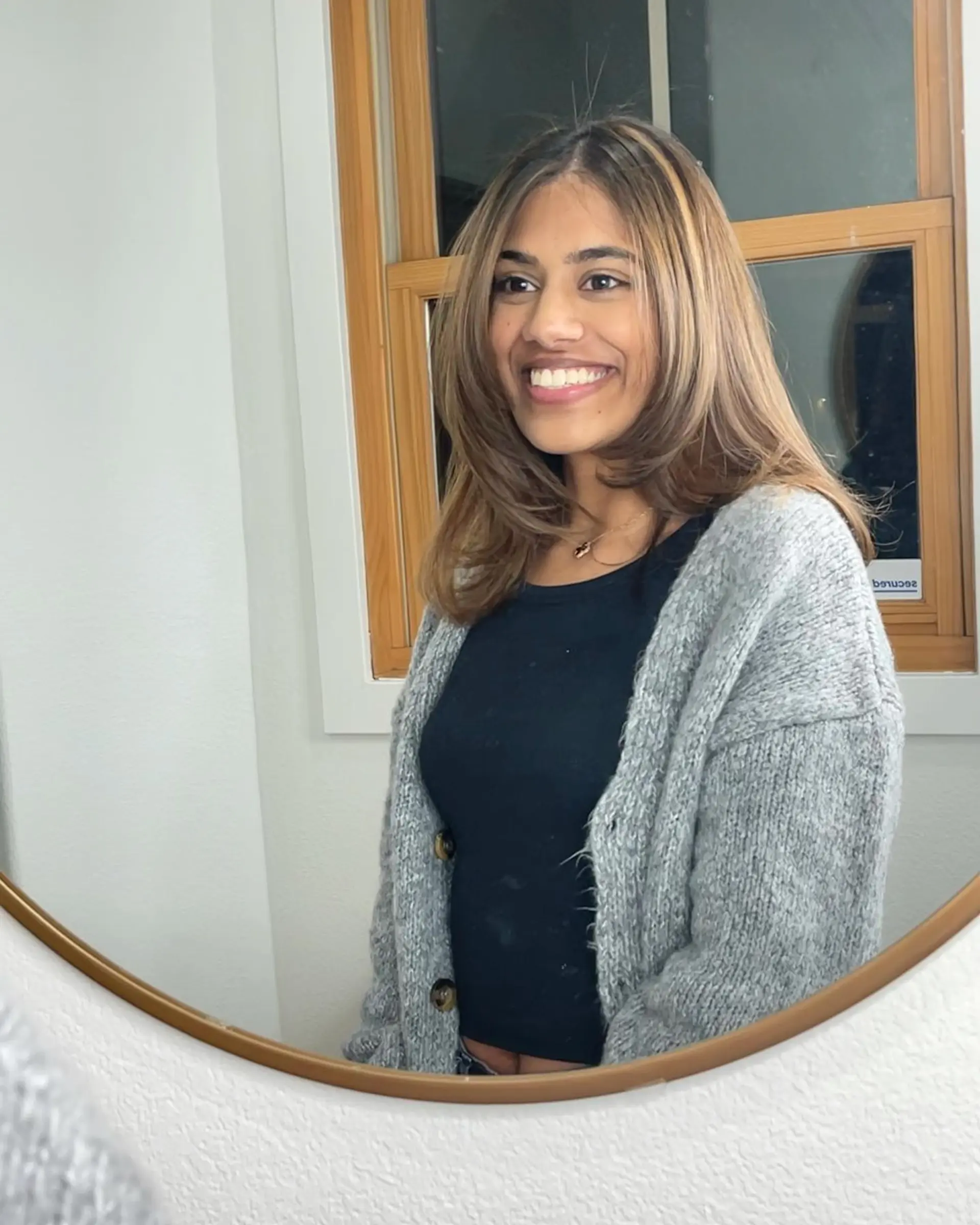 Medium-length hair cut with face-framing layers and styled with a smooth, voluminous blowout curled gently under. 1