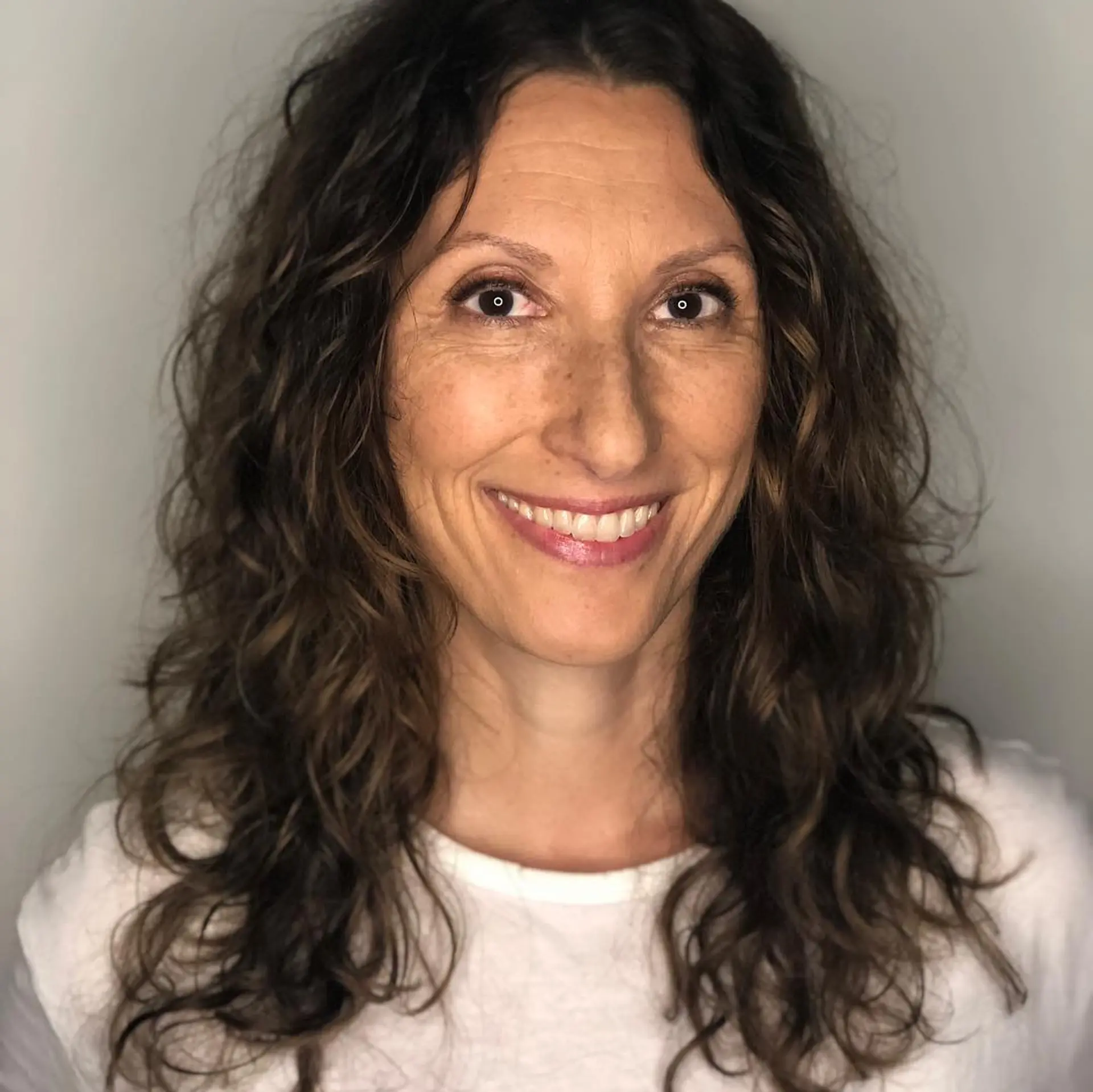 Long naturally curly haircut cut with soft layers to enhance curl definition and volume. 1