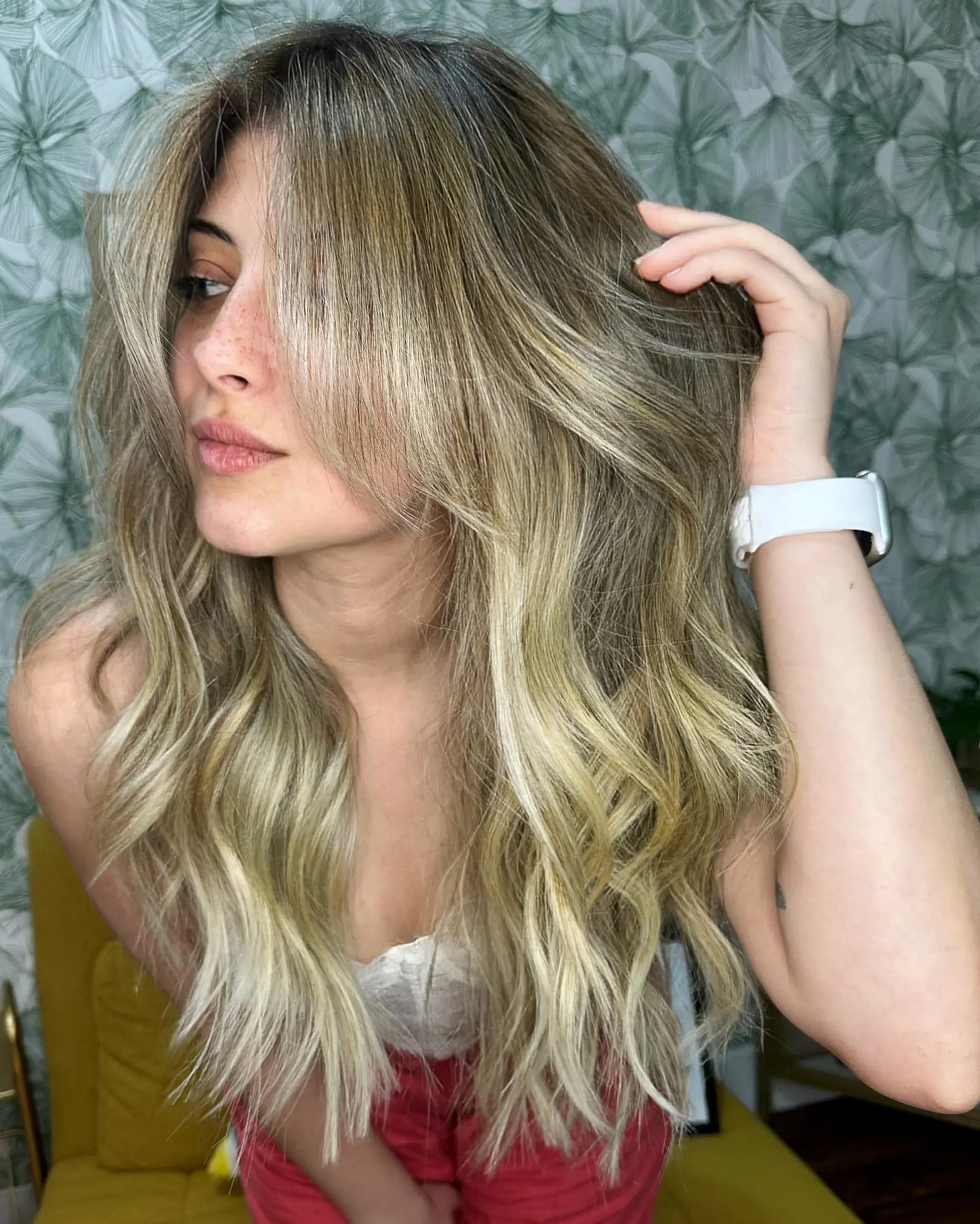 Long dimensional blonde hair featuring seamless balayage highlights, styled with soft textured waves and sweeping face-framing layers. 1