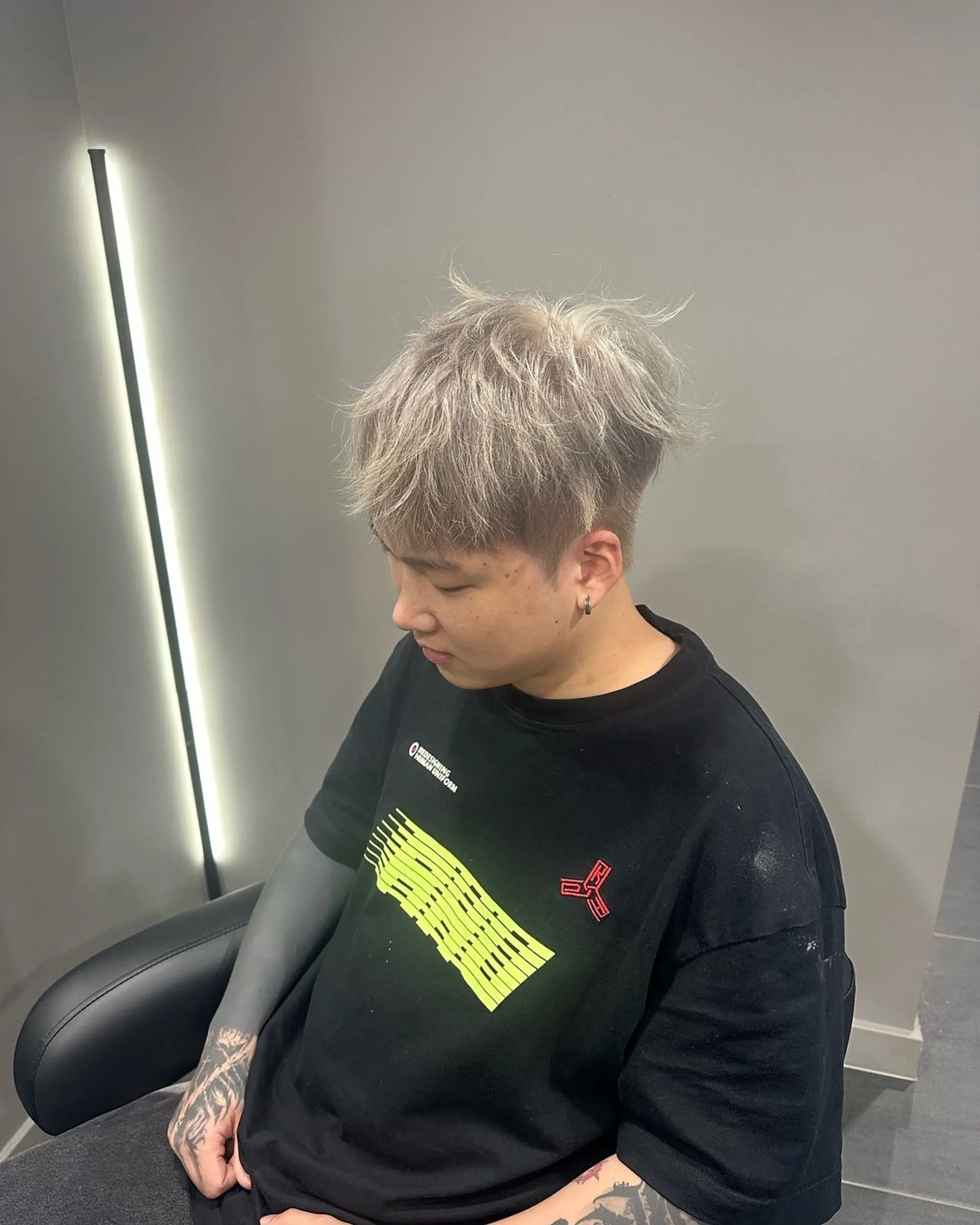 Short, platinum and ash grey hair with a fade undercut and textured, brushed-up top. 1