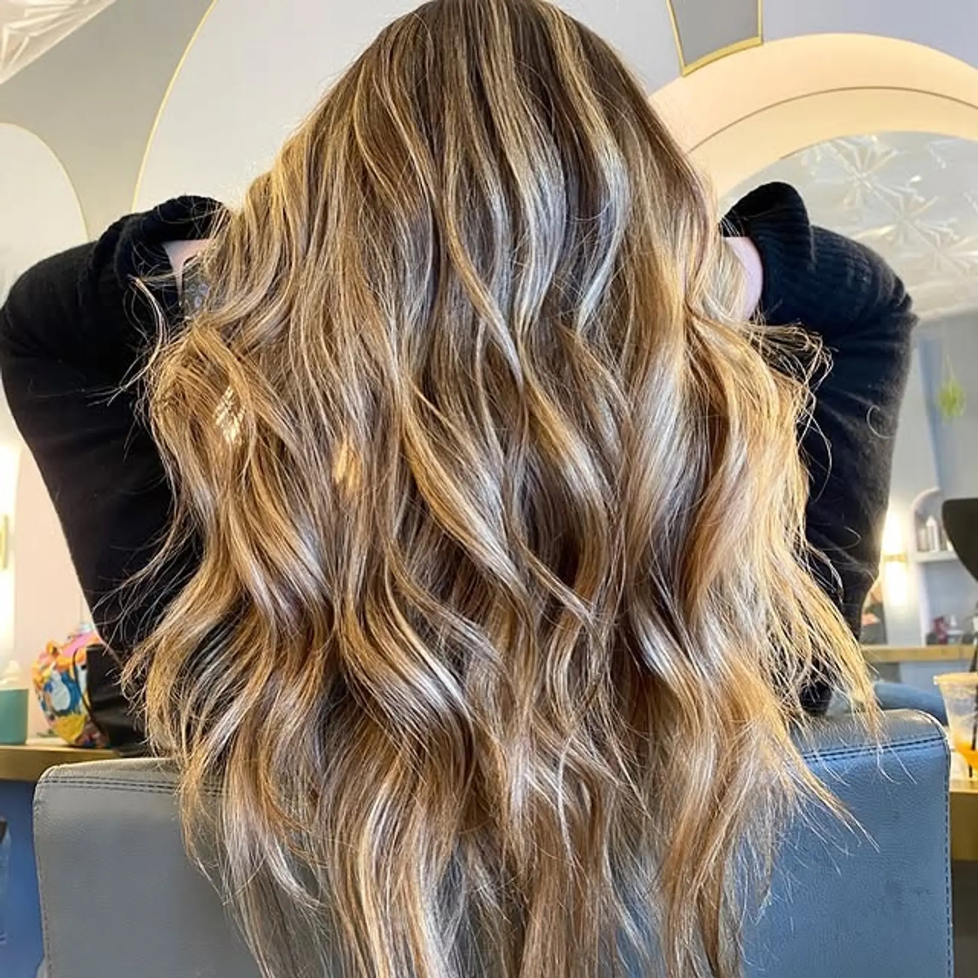 Long, wavy hair with a dimensional bronde color achieved through balayage. 1