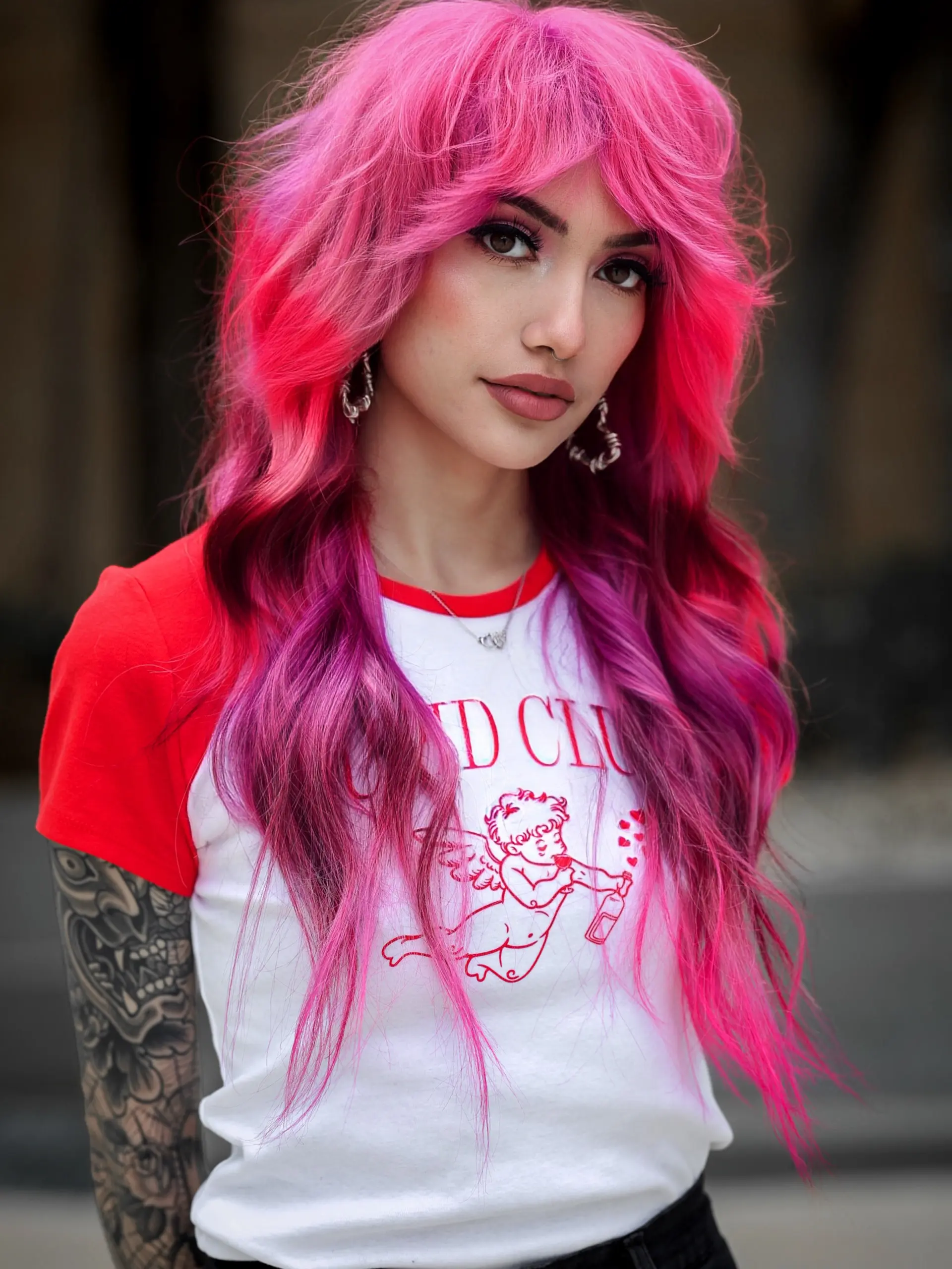 A bold, voluminous layered shag haircut featuring vivid hot pink and magenta hues with textured face-framing curtain bangs. 1