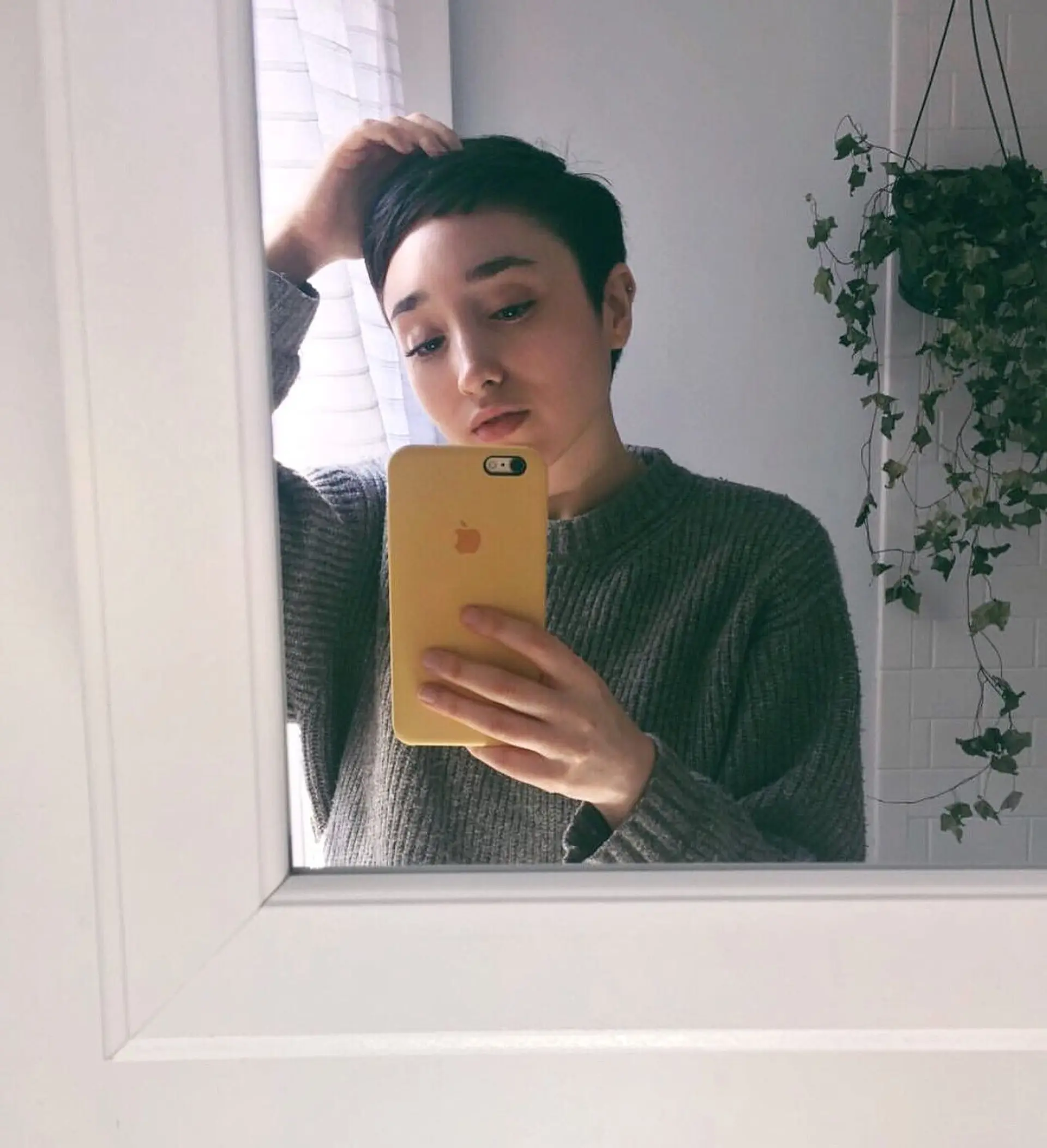 A sleek dark pixie haircut with short micro-bangs and soft razor graduation. 1