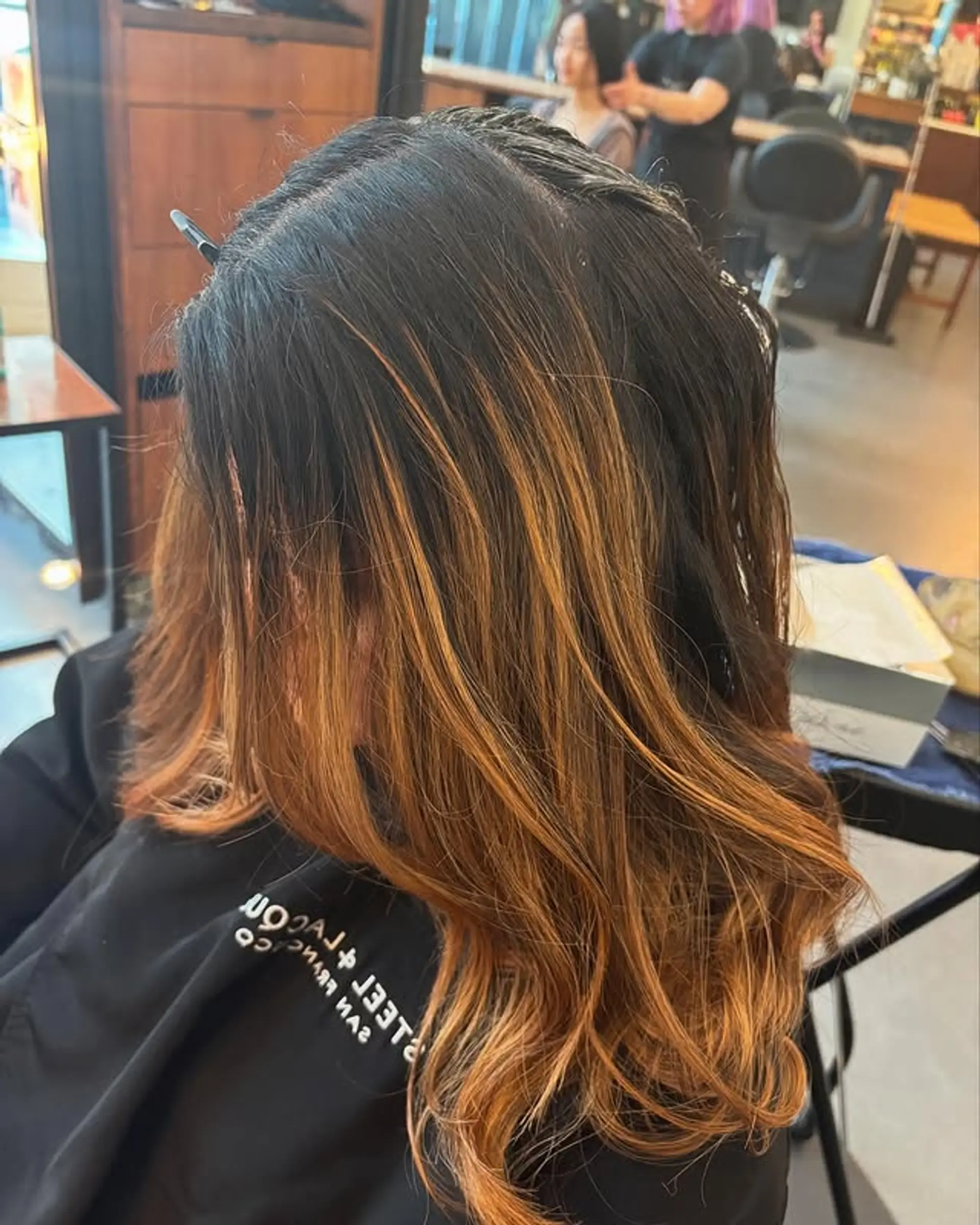 A wavy lob with a balayage featuring a transition from dark roots to copper ends. 1