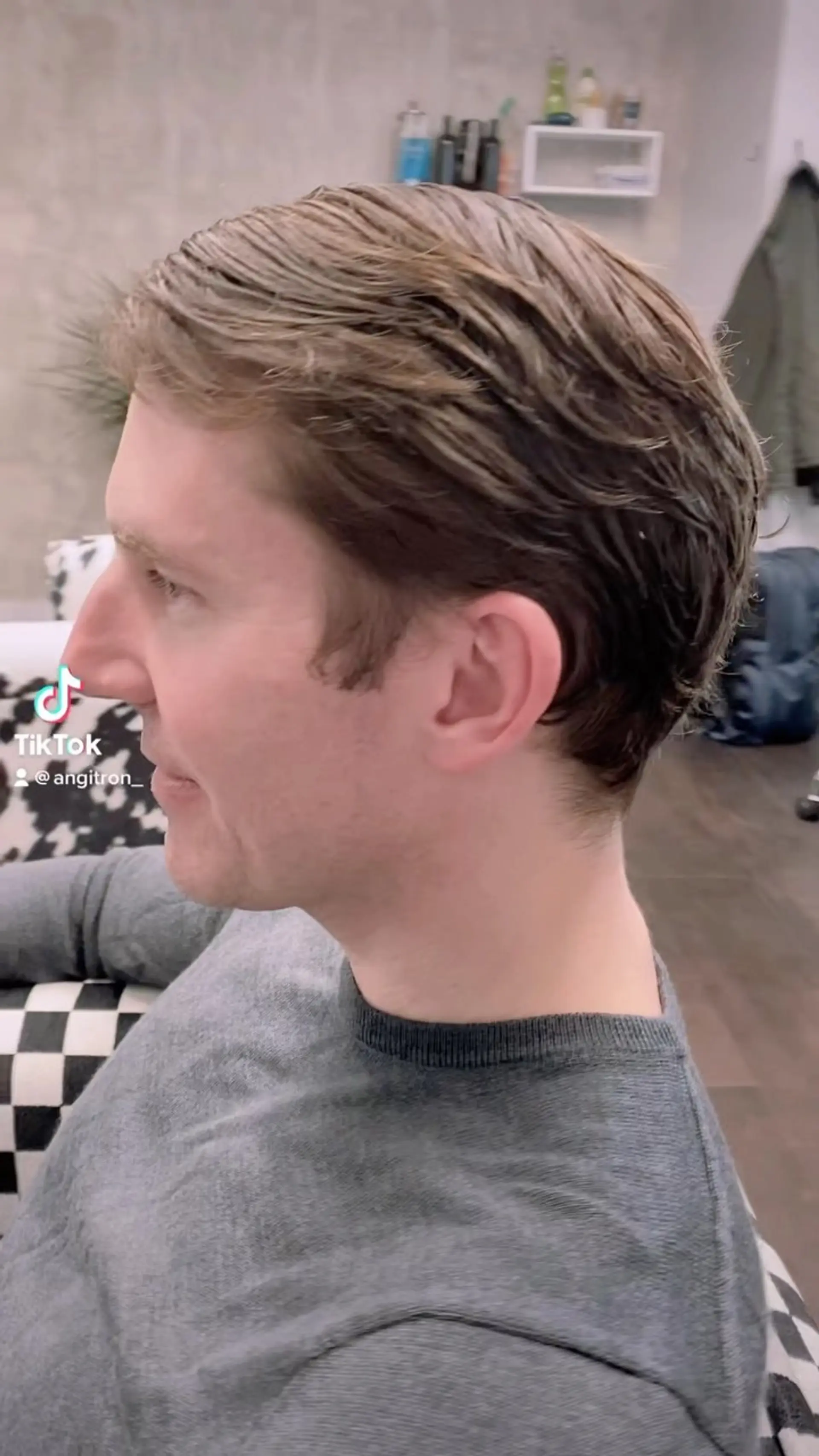 A classic men's short haircut neatly styled and swept back with a natural soft taper at the neck. 1