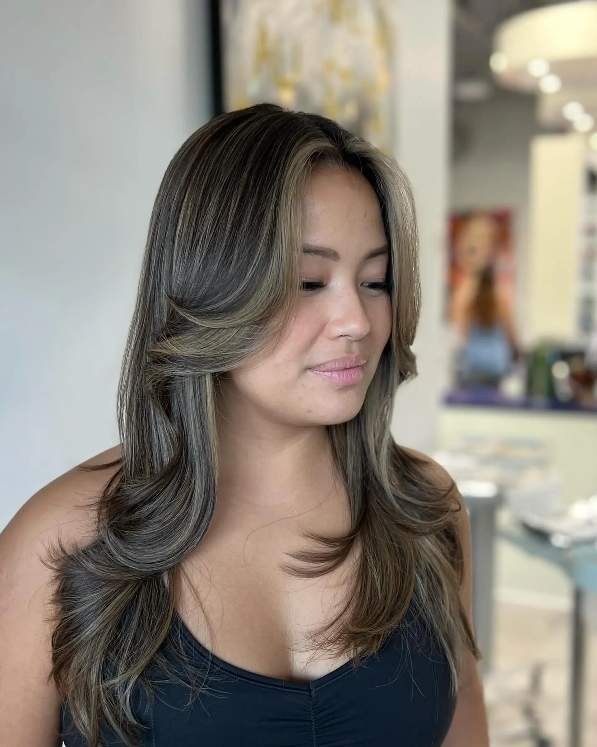 A long layered cut with face-framing layers and 70s-inspired curtain bangs. 2