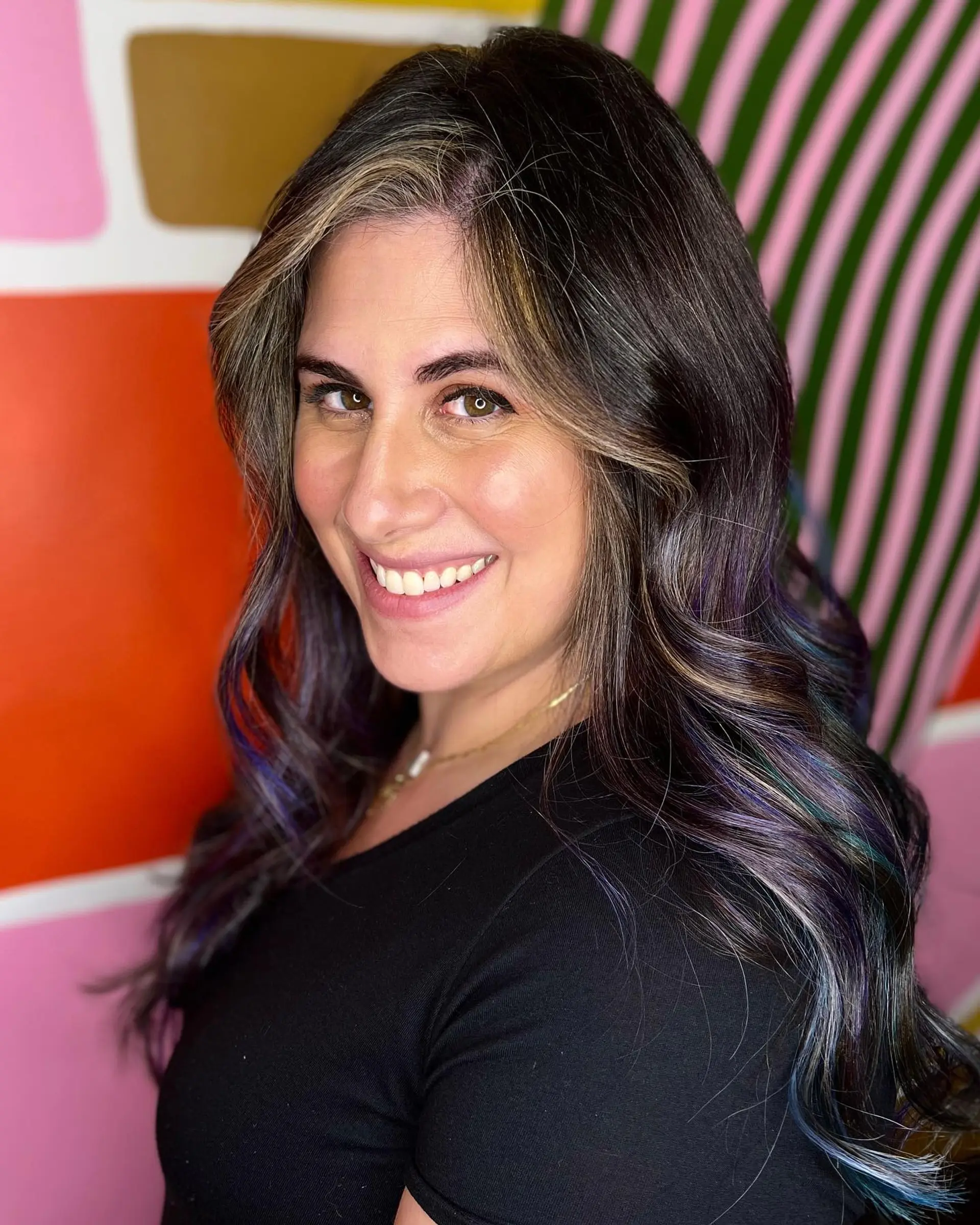 Long dark brown hair styled in glossy loose waves with subtle oil slick highlights in shimmering purple, blue, and teal tones. 1