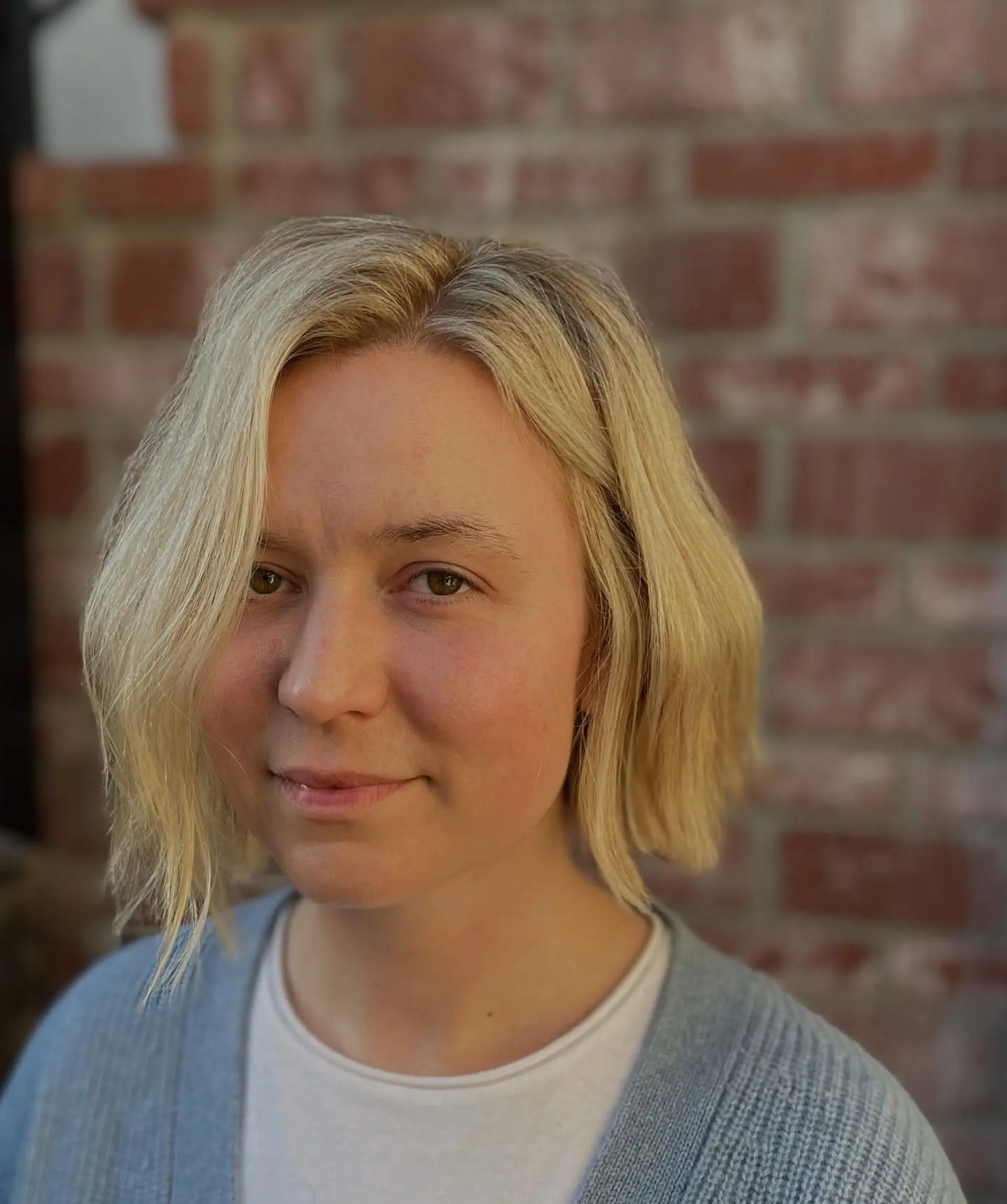 A chin-length blonde bob with soft waves and a side part. 1