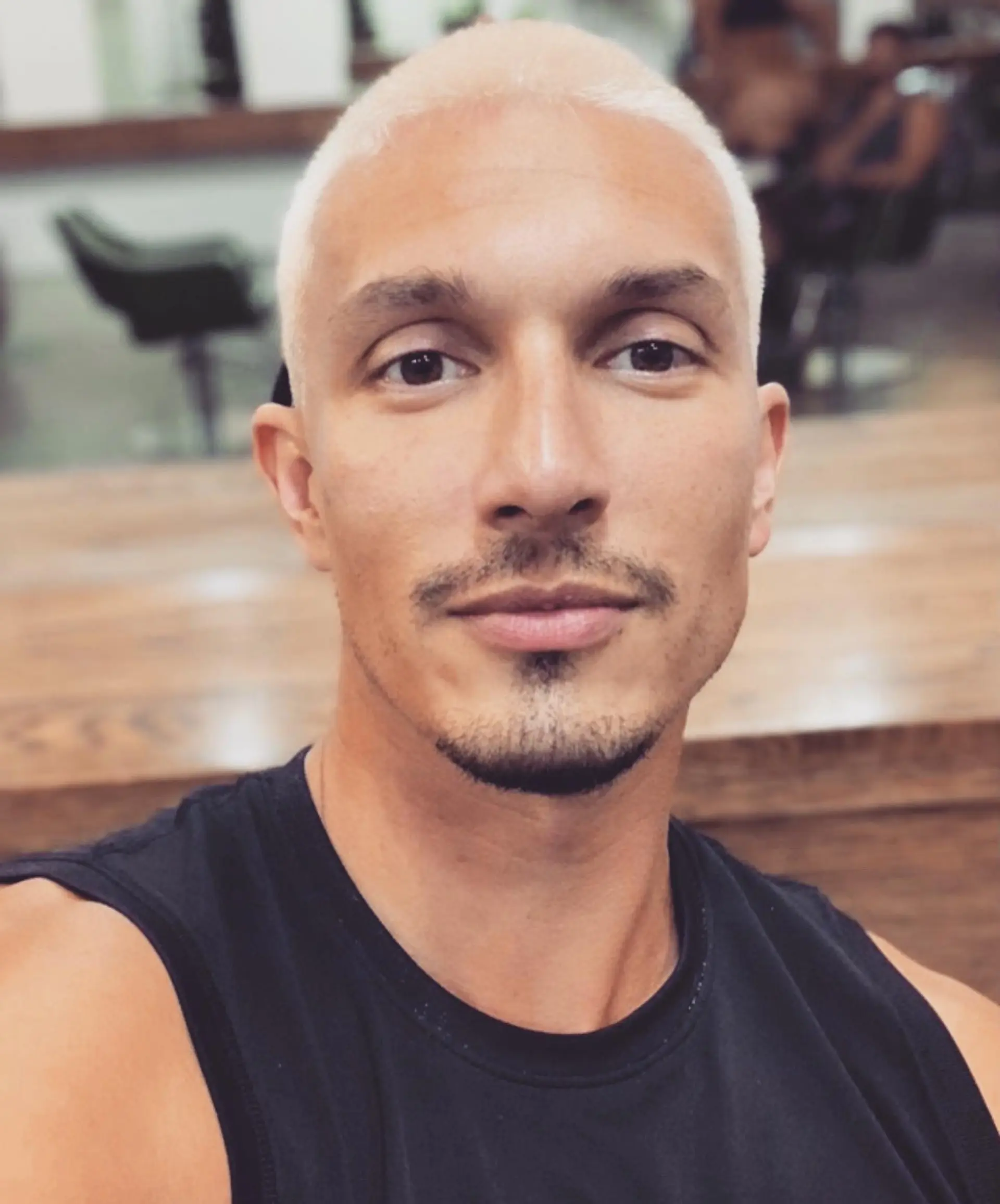 A clean, ultra-short buzz cut lightened to a uniform, pale platinum blonde shade. 1