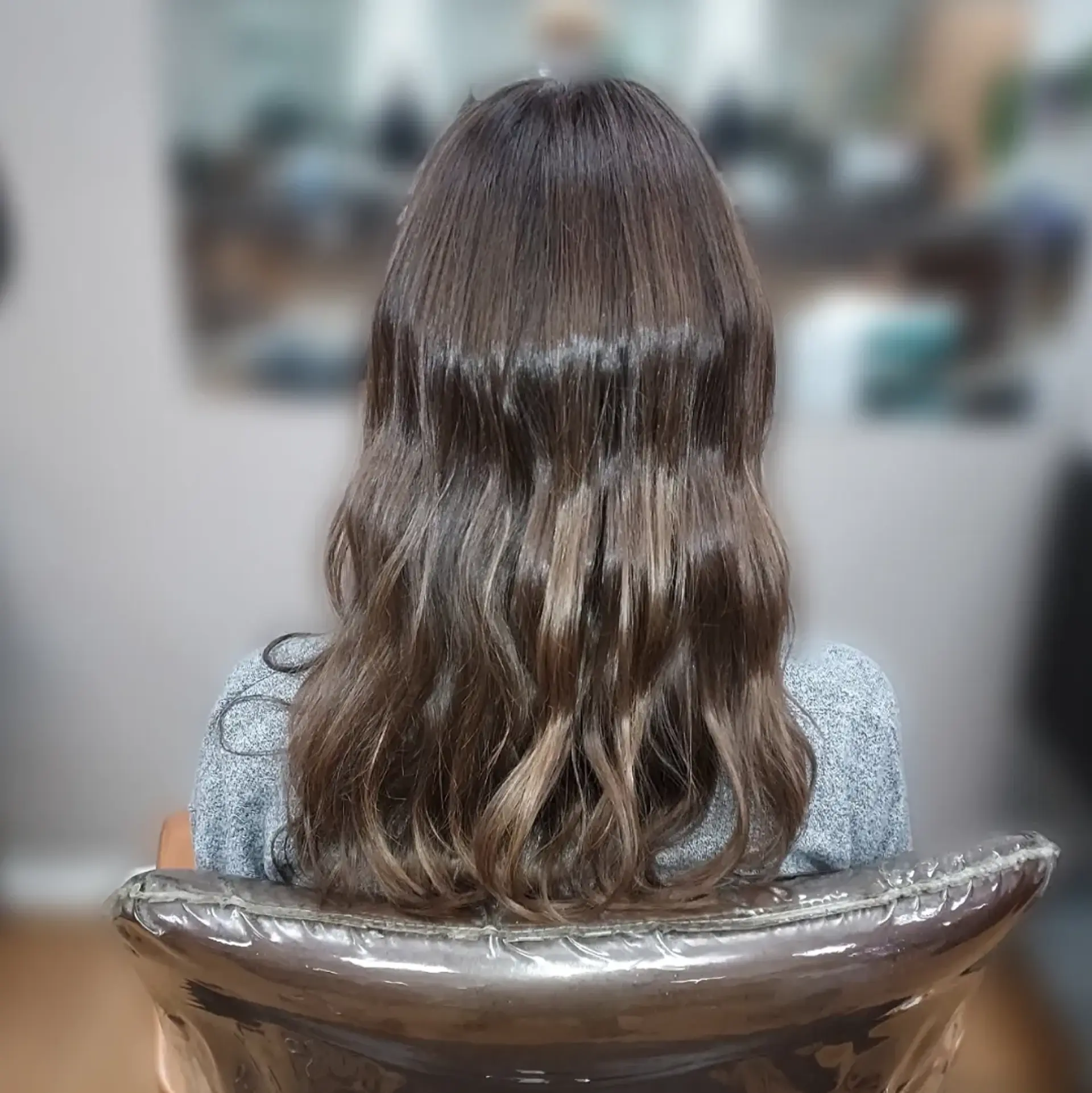 Medium-to-long brunette hair styled into relaxed, soft waves that add natural dimension and movement. 1