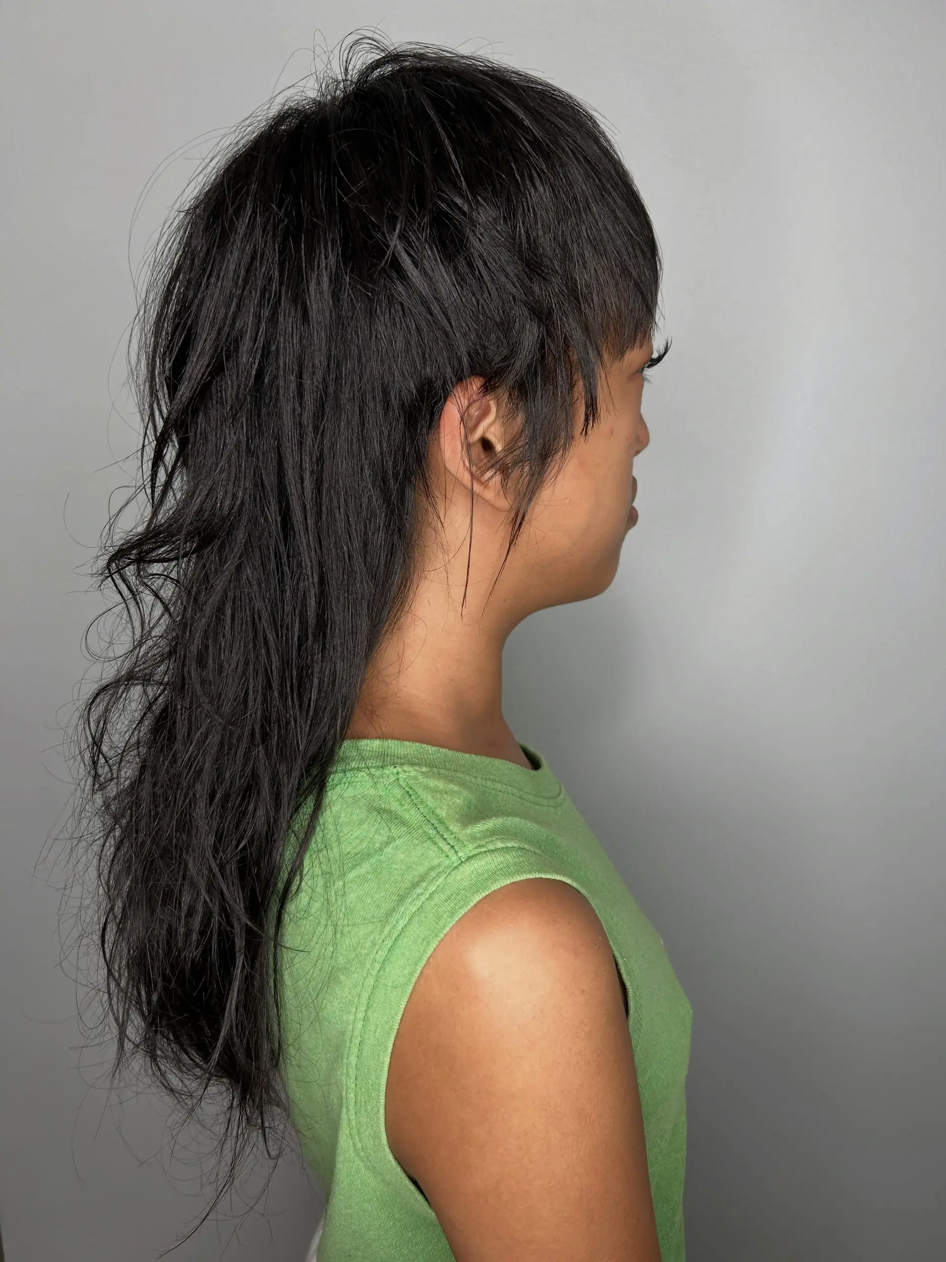 A modern textured mullet featuring choppy, face-framing layers and long, piecey lengths down the back. 1