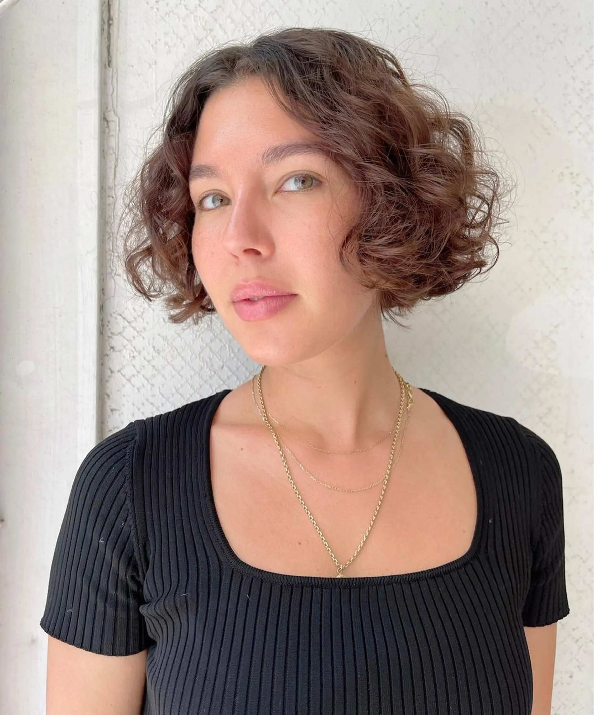 This style is a short, curly bob with soft, natural curls and an effortless volume, offering a chic and youthful appearance. 1