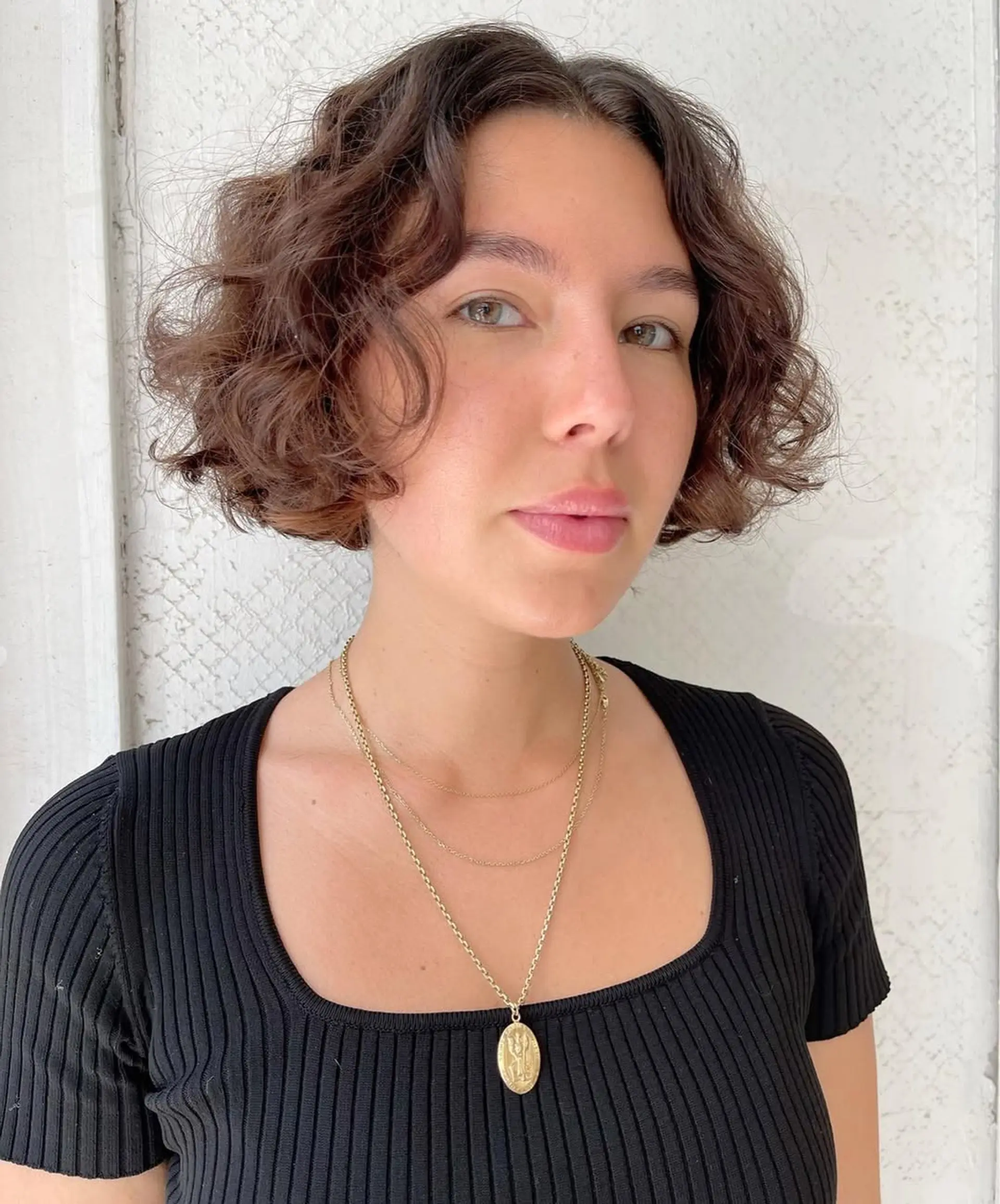 This style is a short, curly bob with soft, natural curls and an effortless volume, offering a chic and youthful appearance. 2