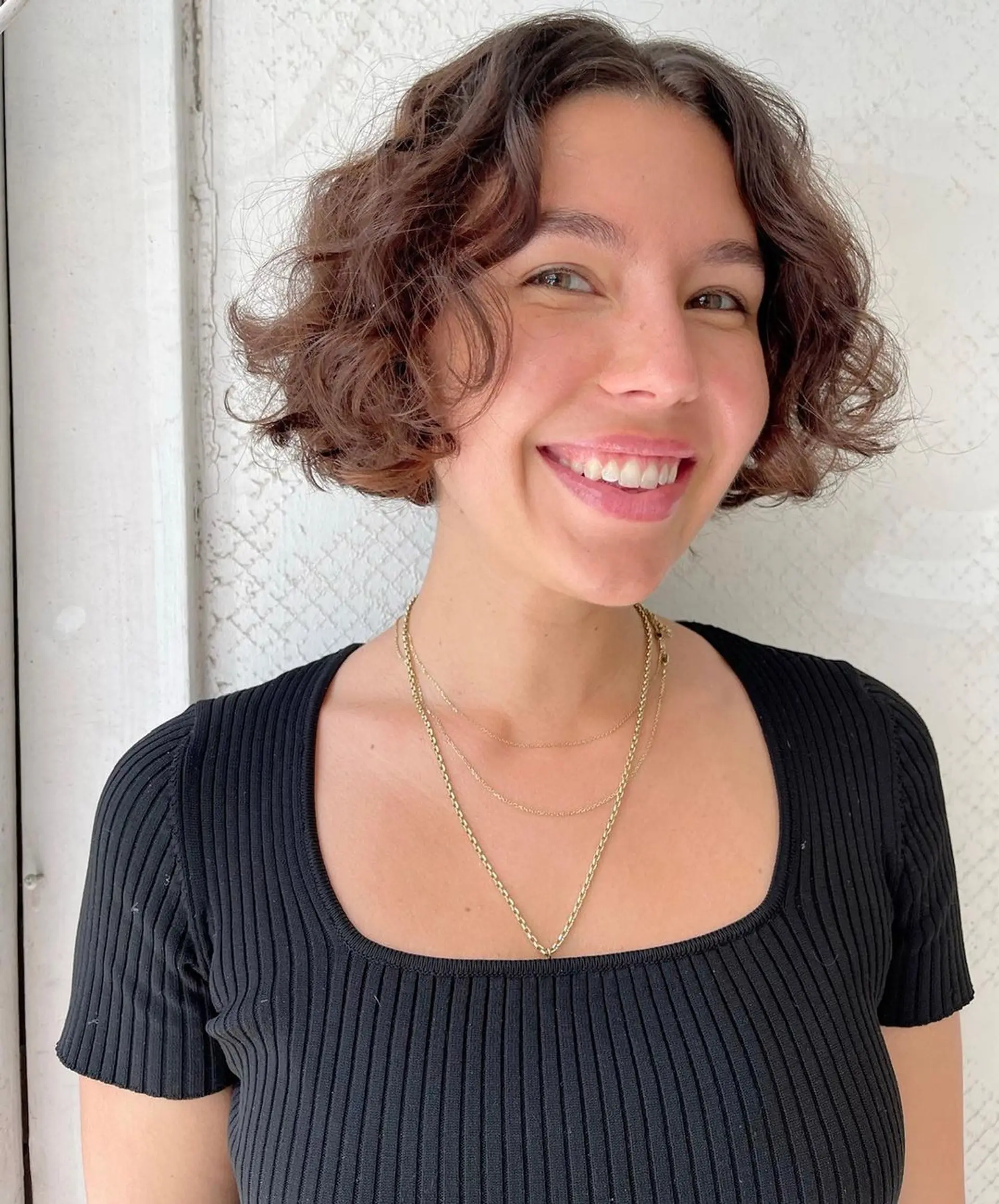 This style is a short, curly bob with soft, natural curls and an effortless volume, offering a chic and youthful appearance. 3