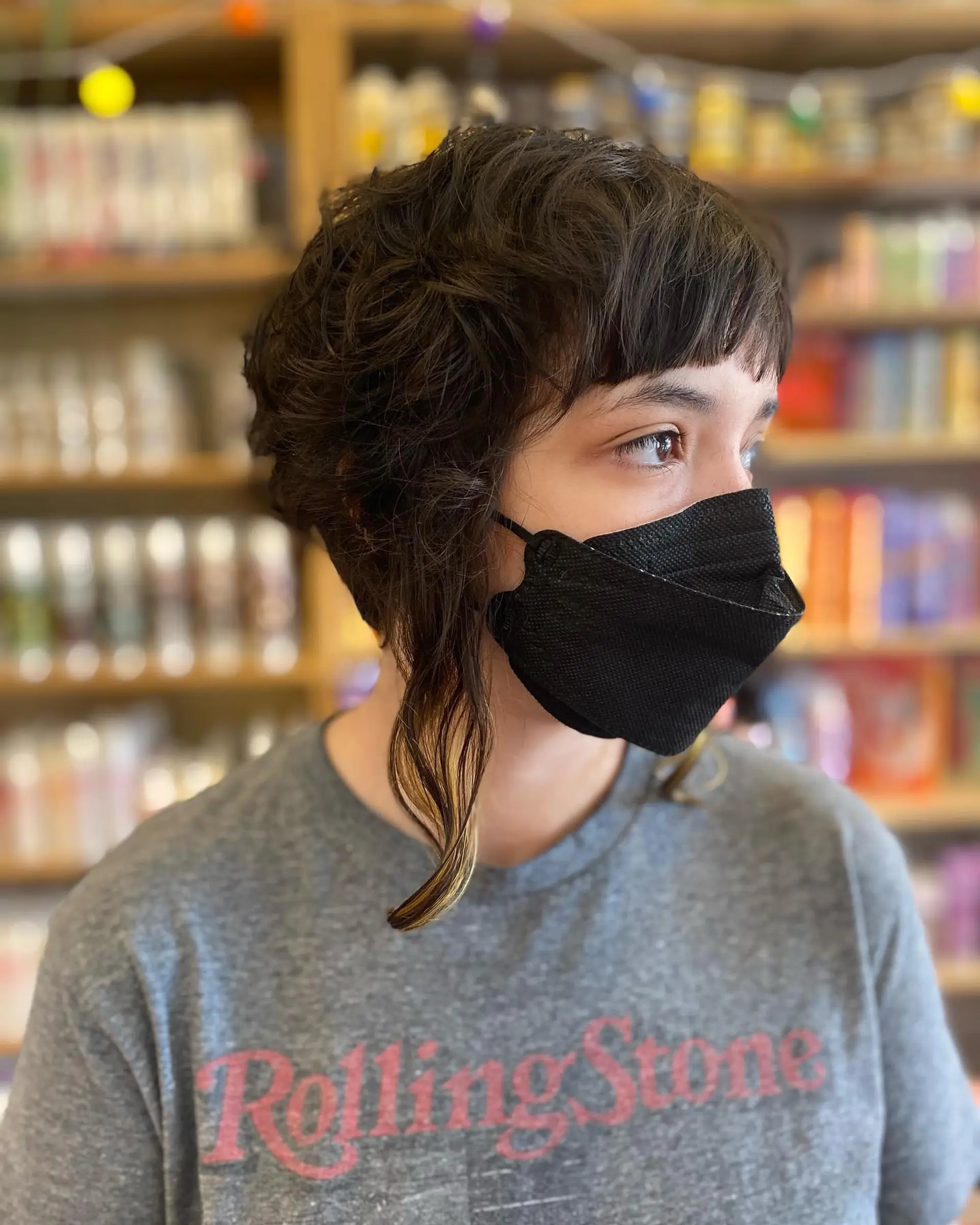 A modern shaggy bob with choppy layers and short baby bangs. The haircut has an edgy, textured look. 1