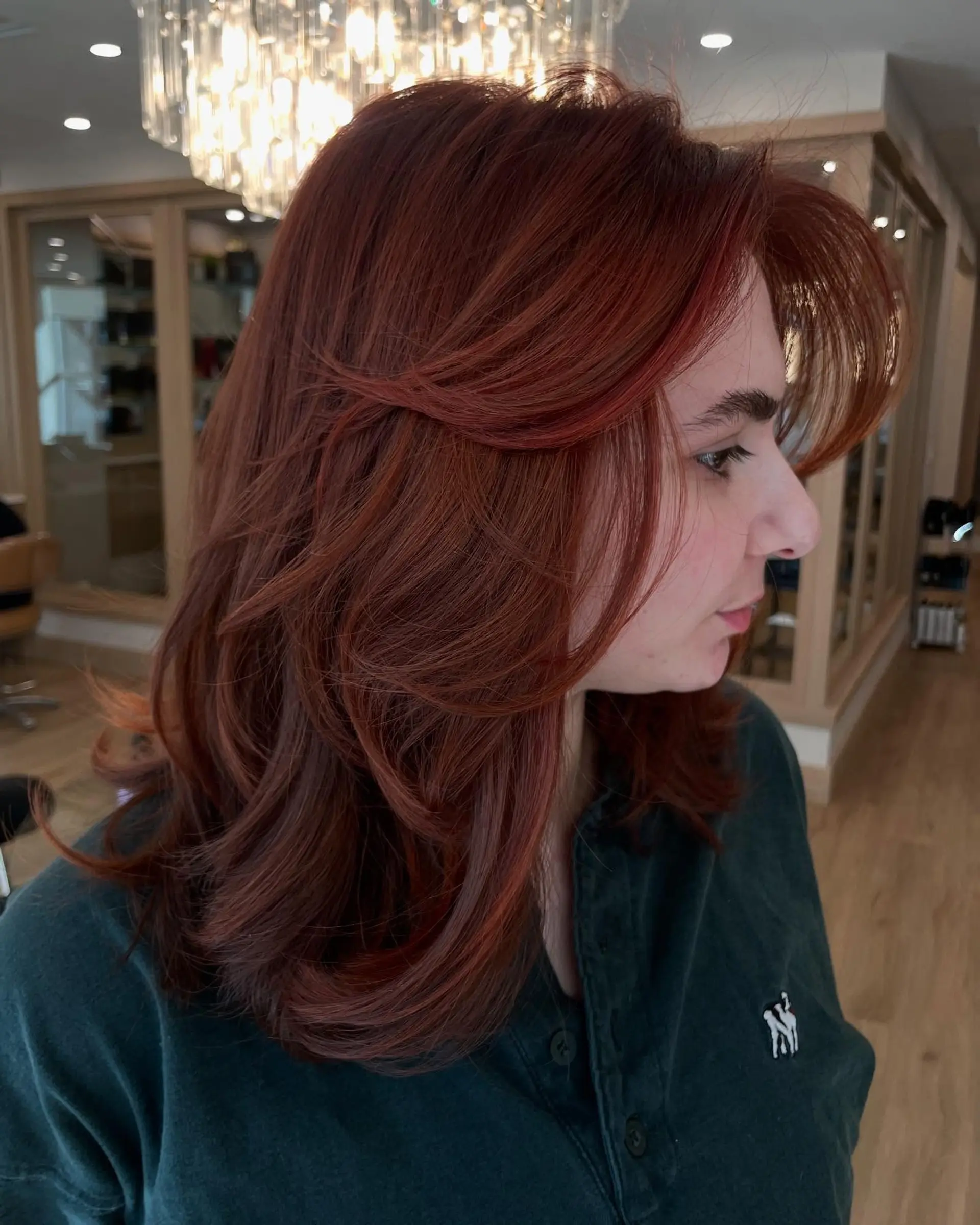 A medium-length layered haircut with face-framing layers and a shaggy texture. 2