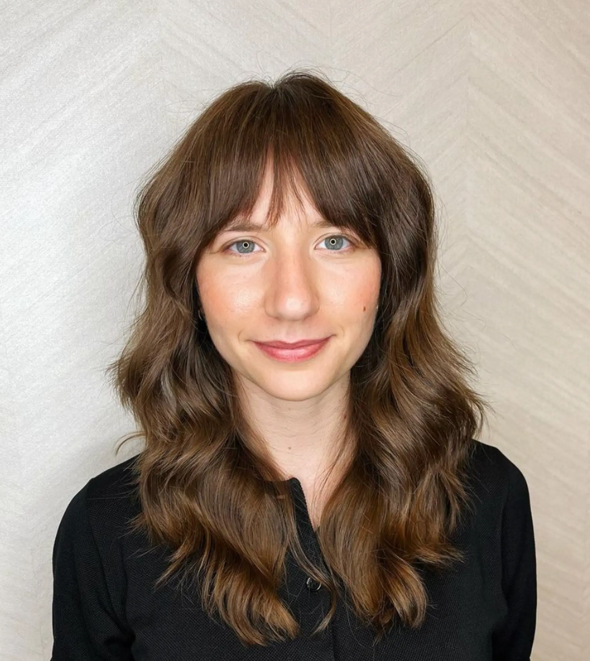 Medium-length, wavy hair with soft waves and fringe bangs, featuring a layered cut to enhance natural movement and texture in a medium brown color.

Cut and style by @juliamannino_hair
 1