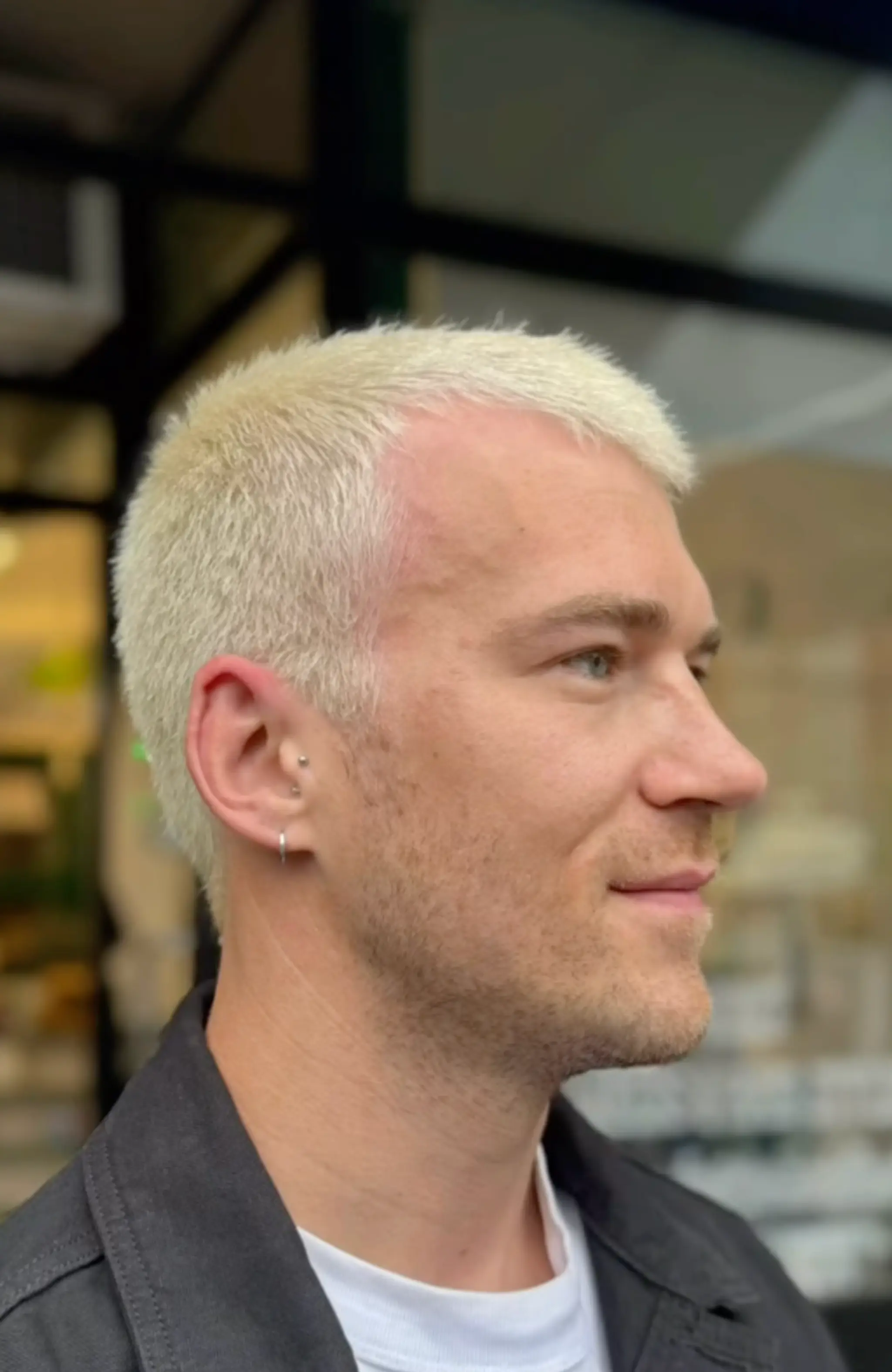 A very short, straight buzzcut with platinum blonde color.