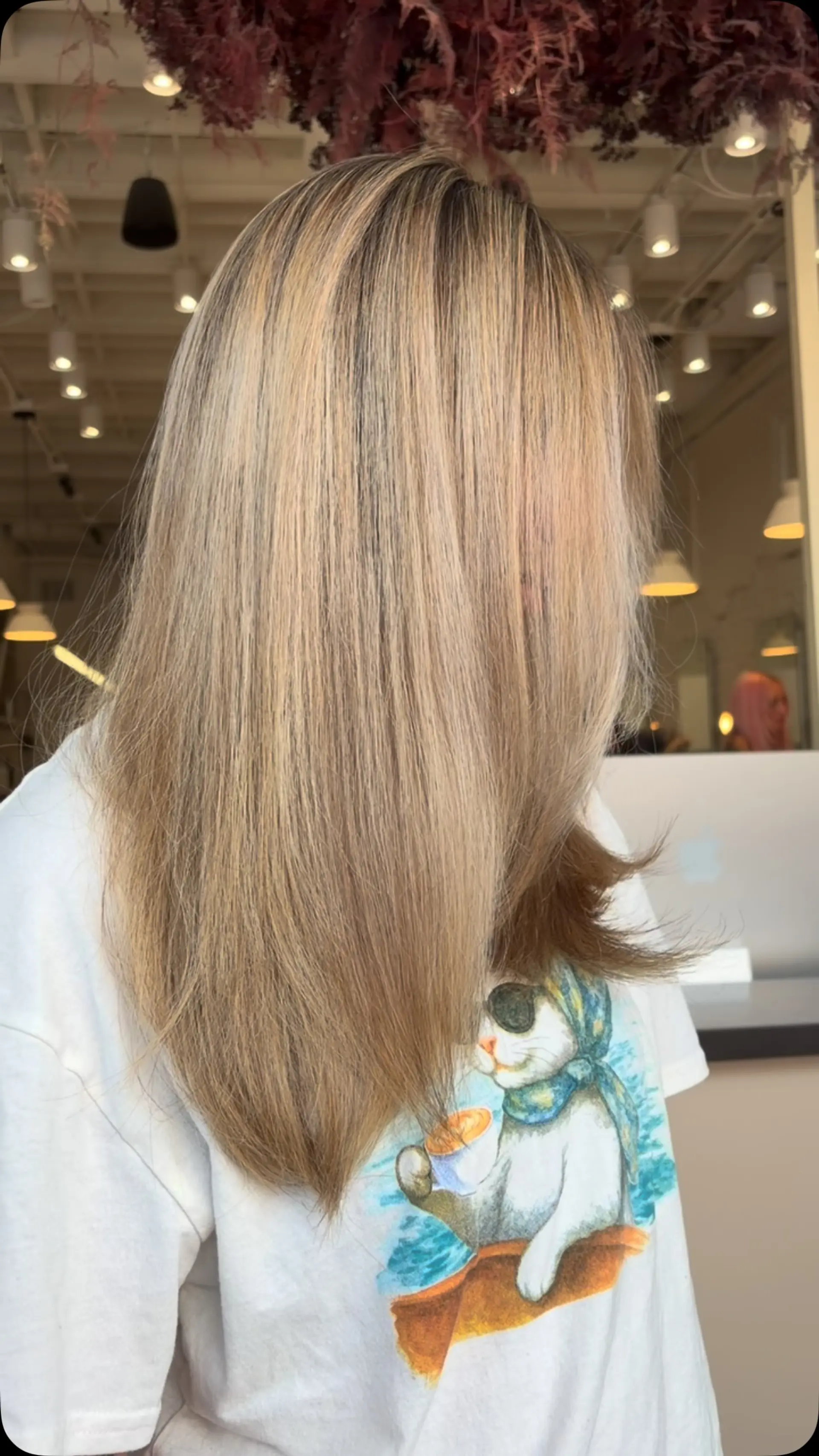 A sleek, straight long style featuring warm teddy blonde dimensional highlights. 1
