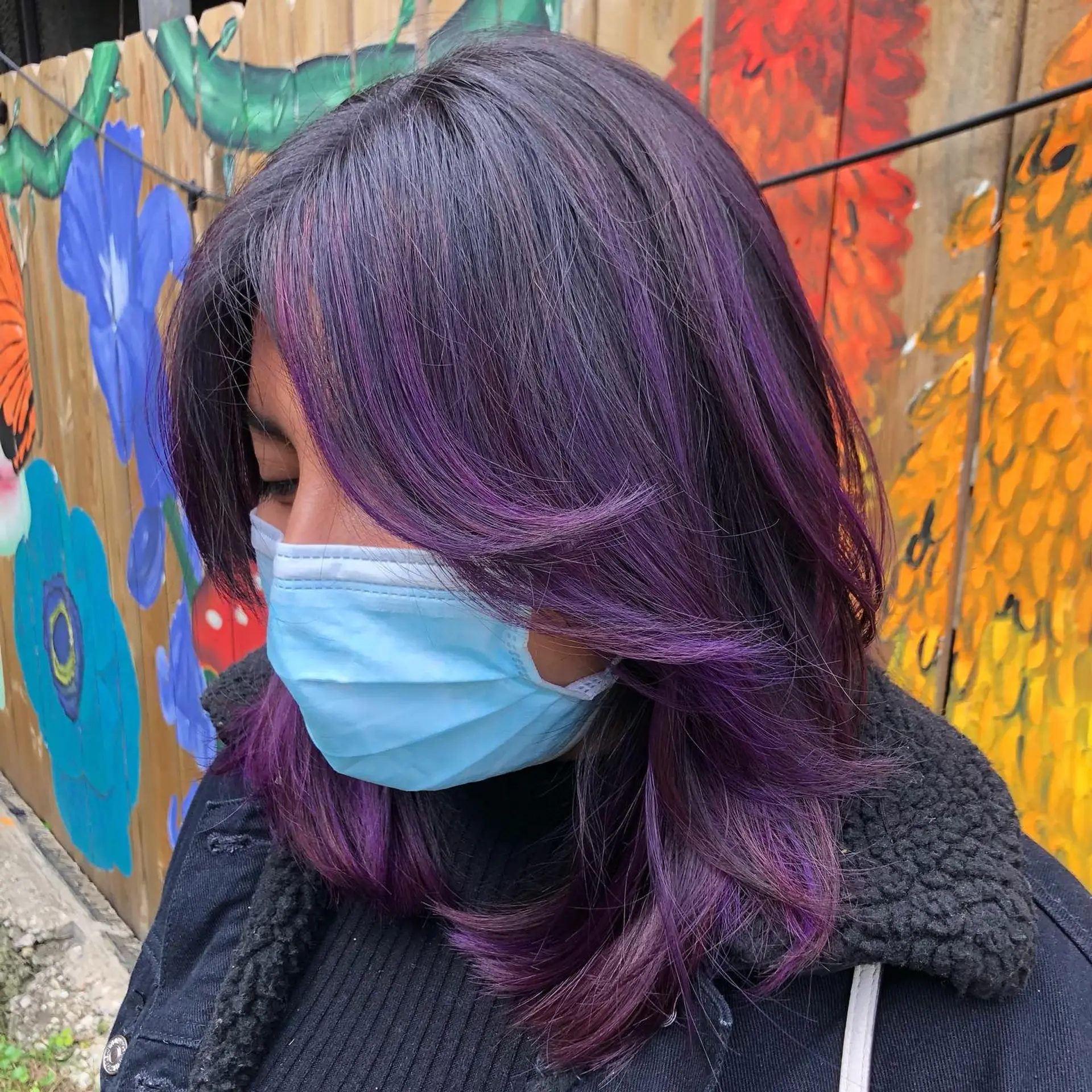 A medium length layered haircut with face framing layers and amethyst purple highlights. 1