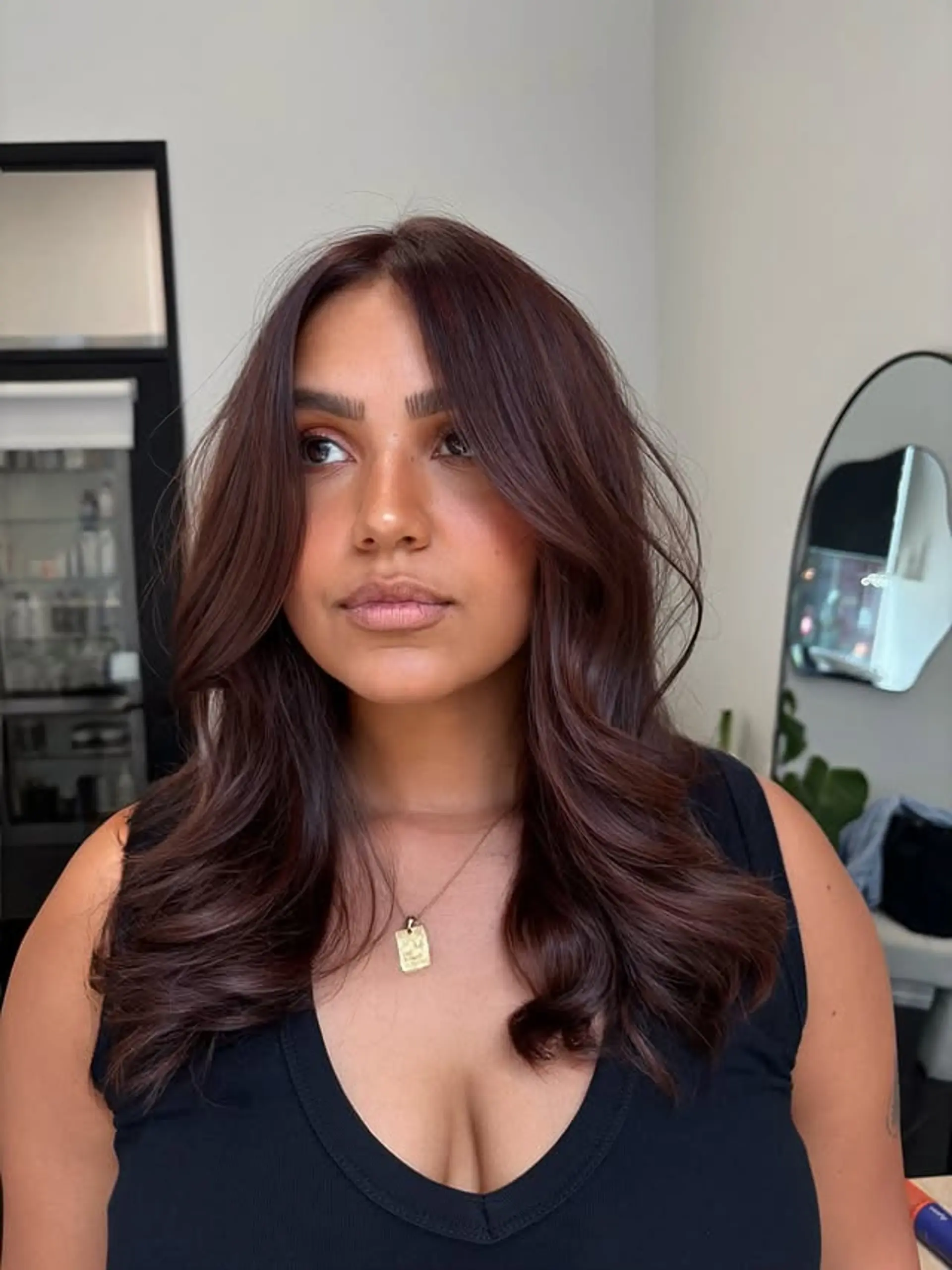 A medium-length wavy hairstyle with soft waves and face-framing layers. 1