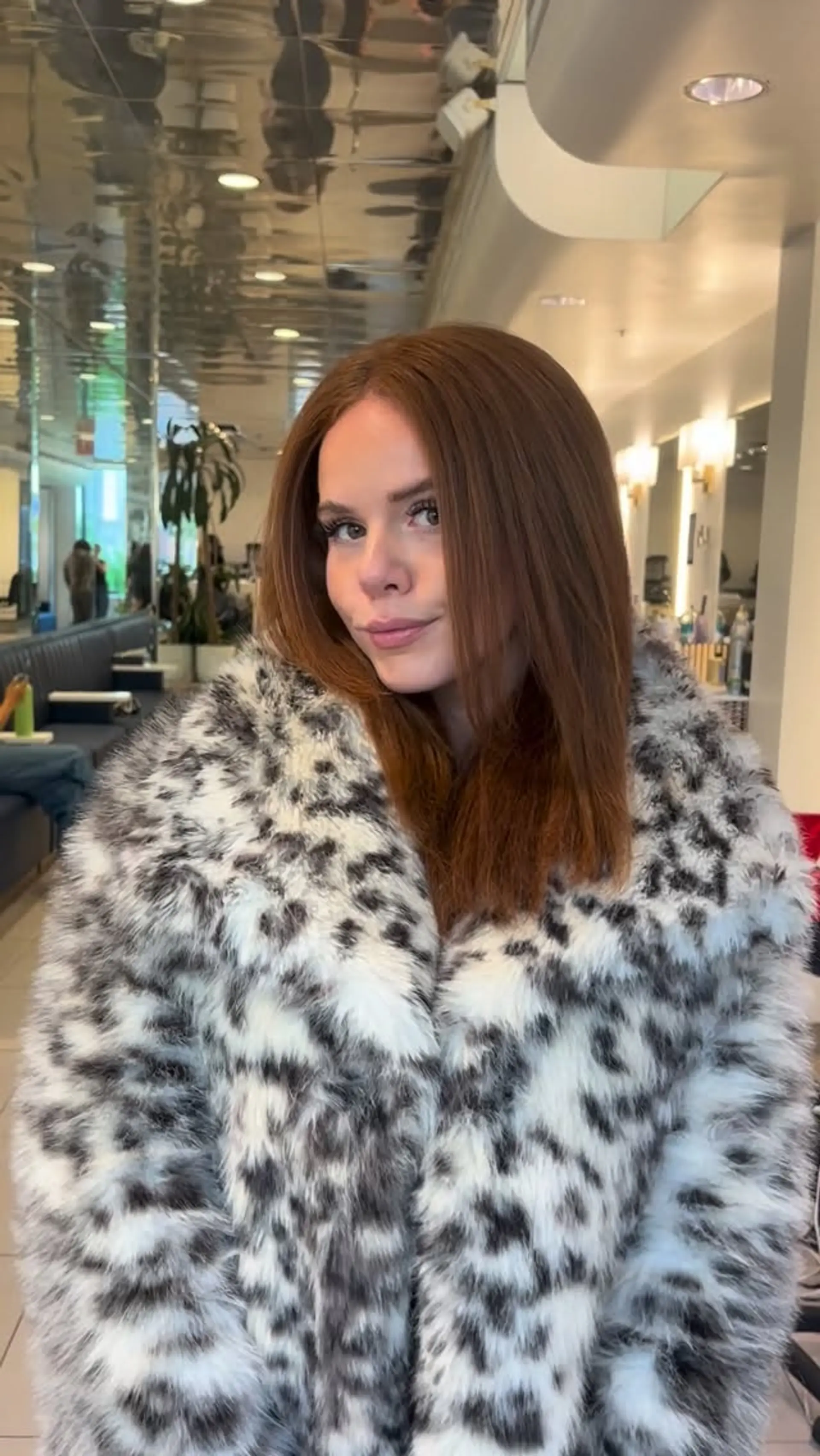 A sleek and smooth medium-length blowout with a middle part in rich auburn tones. 1