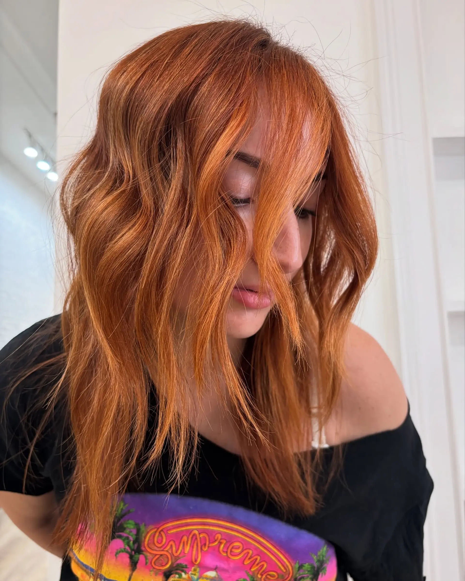 Shoulder-length vibrant copper hair styled into soft, effortless waves. 1