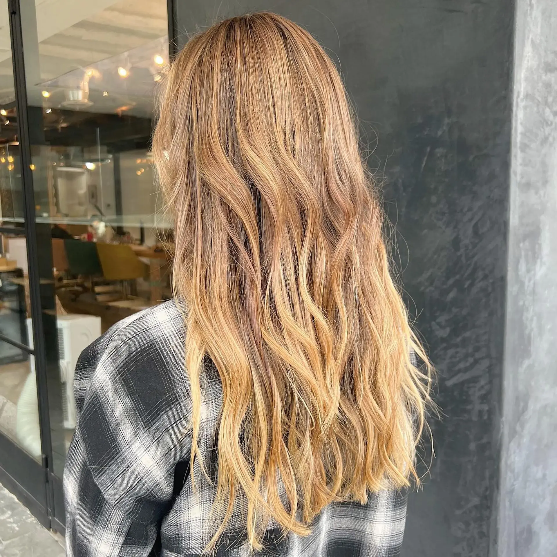 Long, flowing wavy hair with a golden blonde balayage. 2