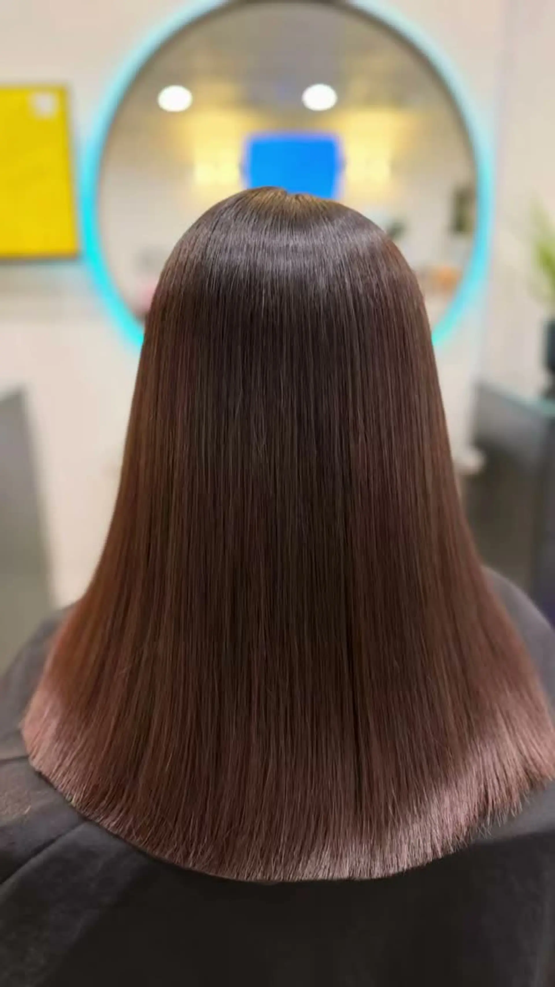Ultra-sleek, pin-straight medium-length brunette hair with an immaculate, high-shine glass-like finish. 1