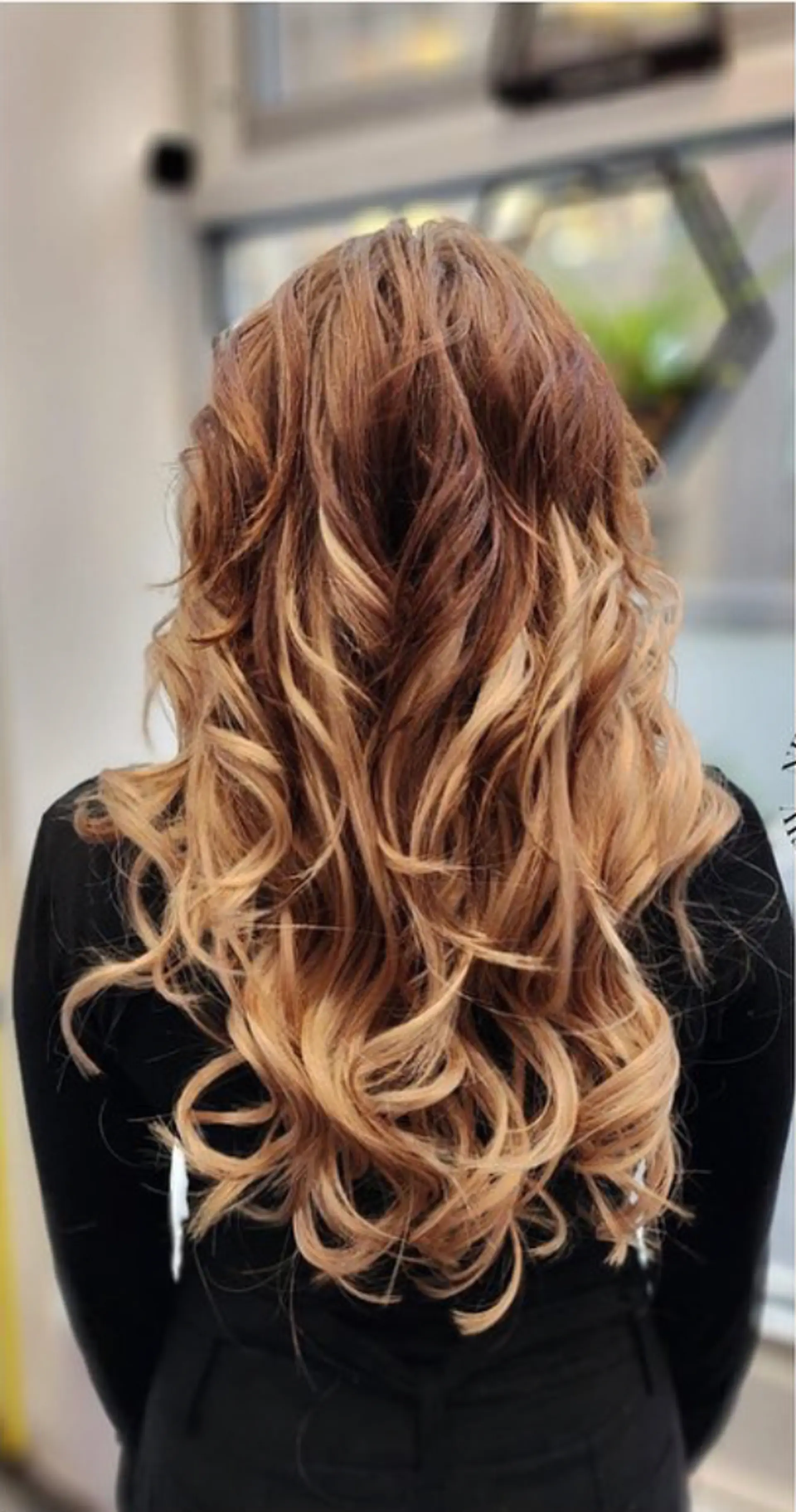 Very long, wavy keratin bond extensions with a light brown to blonde ombre transition and loose, voluminous waves. Layered for added texture and body. 1