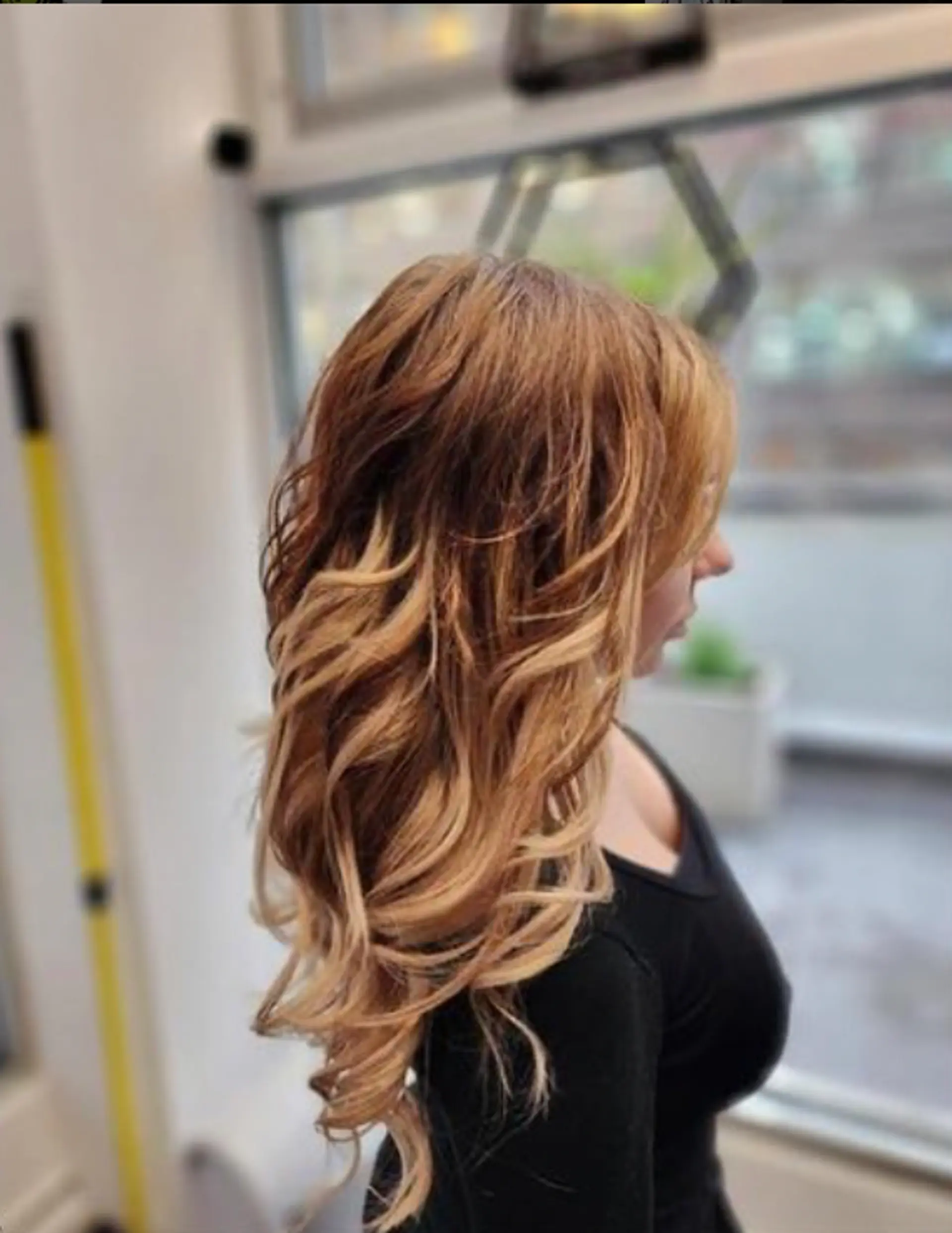Very long, wavy keratin bond extensions with a light brown to blonde ombre transition and loose, voluminous waves. Layered for added texture and body. 2