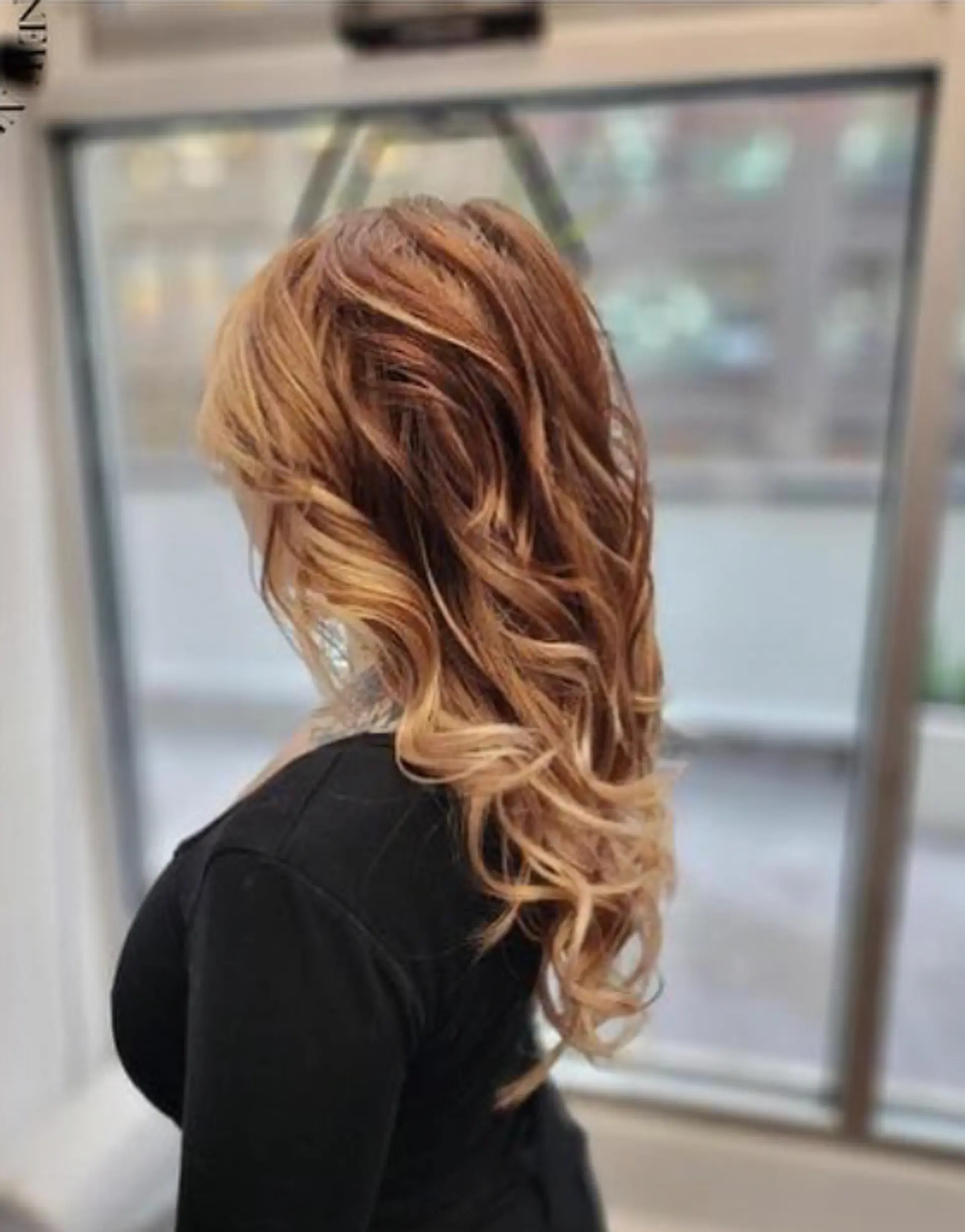 Very long, wavy keratin bond extensions with a light brown to blonde ombre transition and loose, voluminous waves. Layered for added texture and body. 3