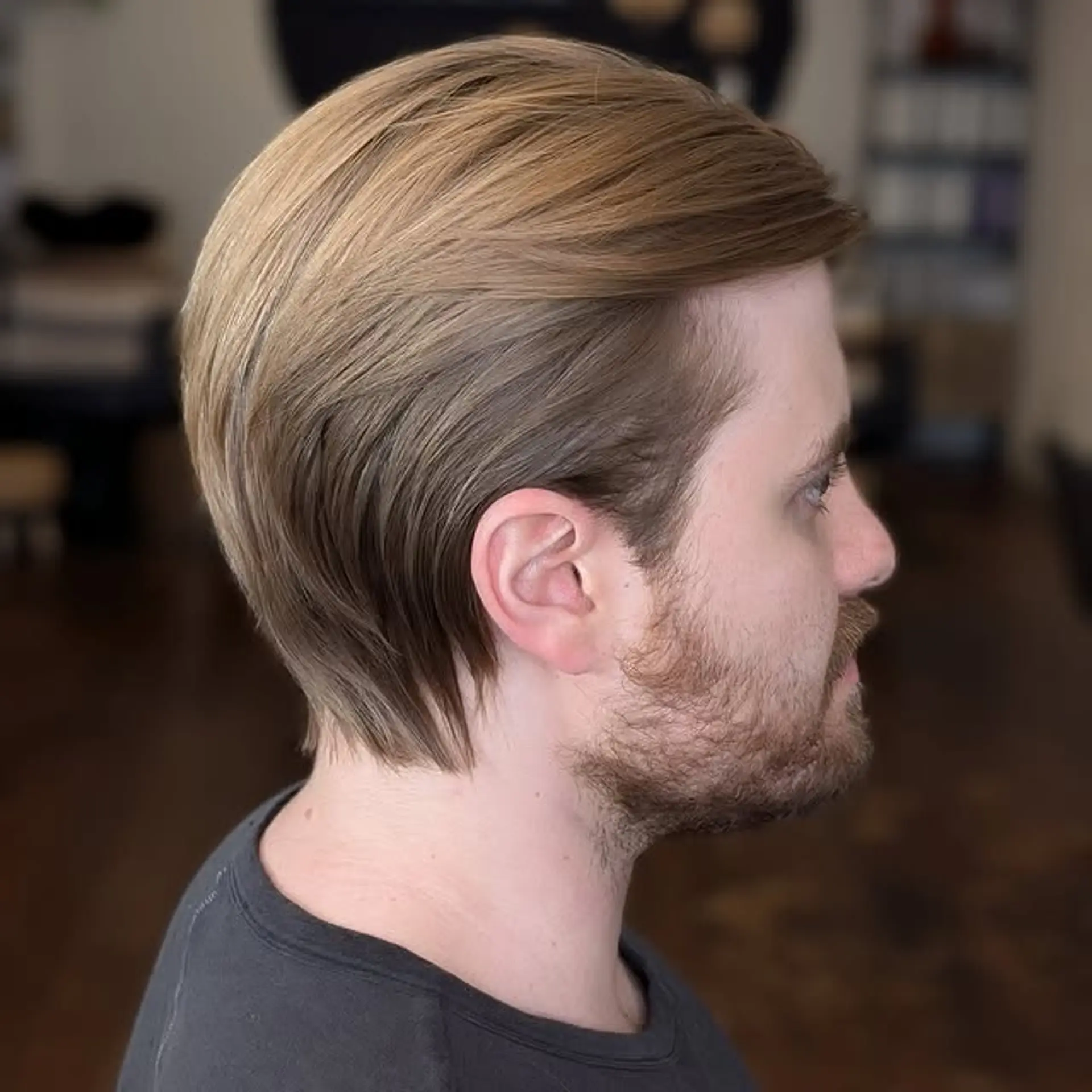 A slicked-back medium-length hairstyle with tapered sides. 1