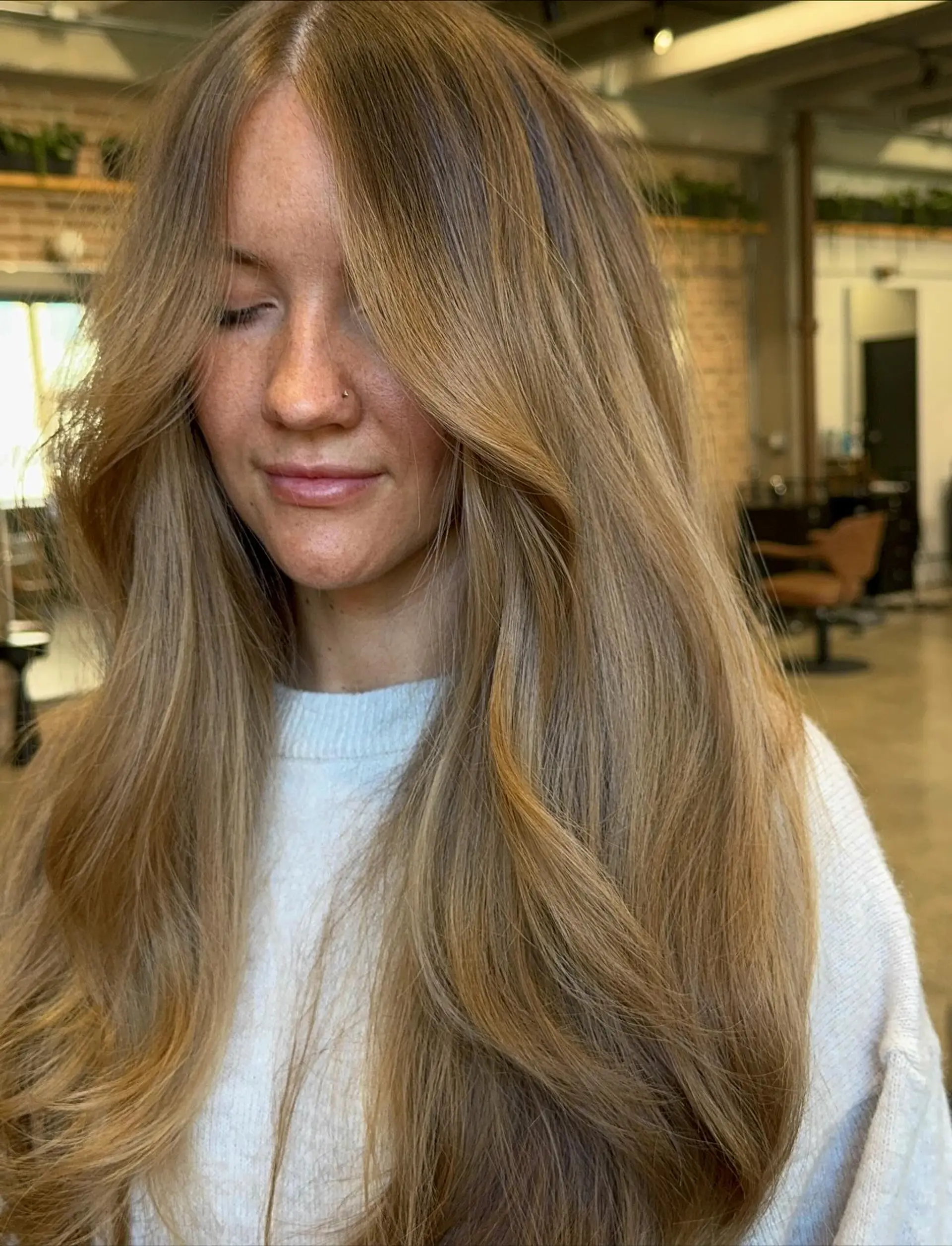 This style features very long hair with soft, cascading layers that add volume and movement. Face-framing layers gently sweep back from the face, creating a soft, flattering outline. The overall look is effortlessly chic with a natural wavy finish. 1