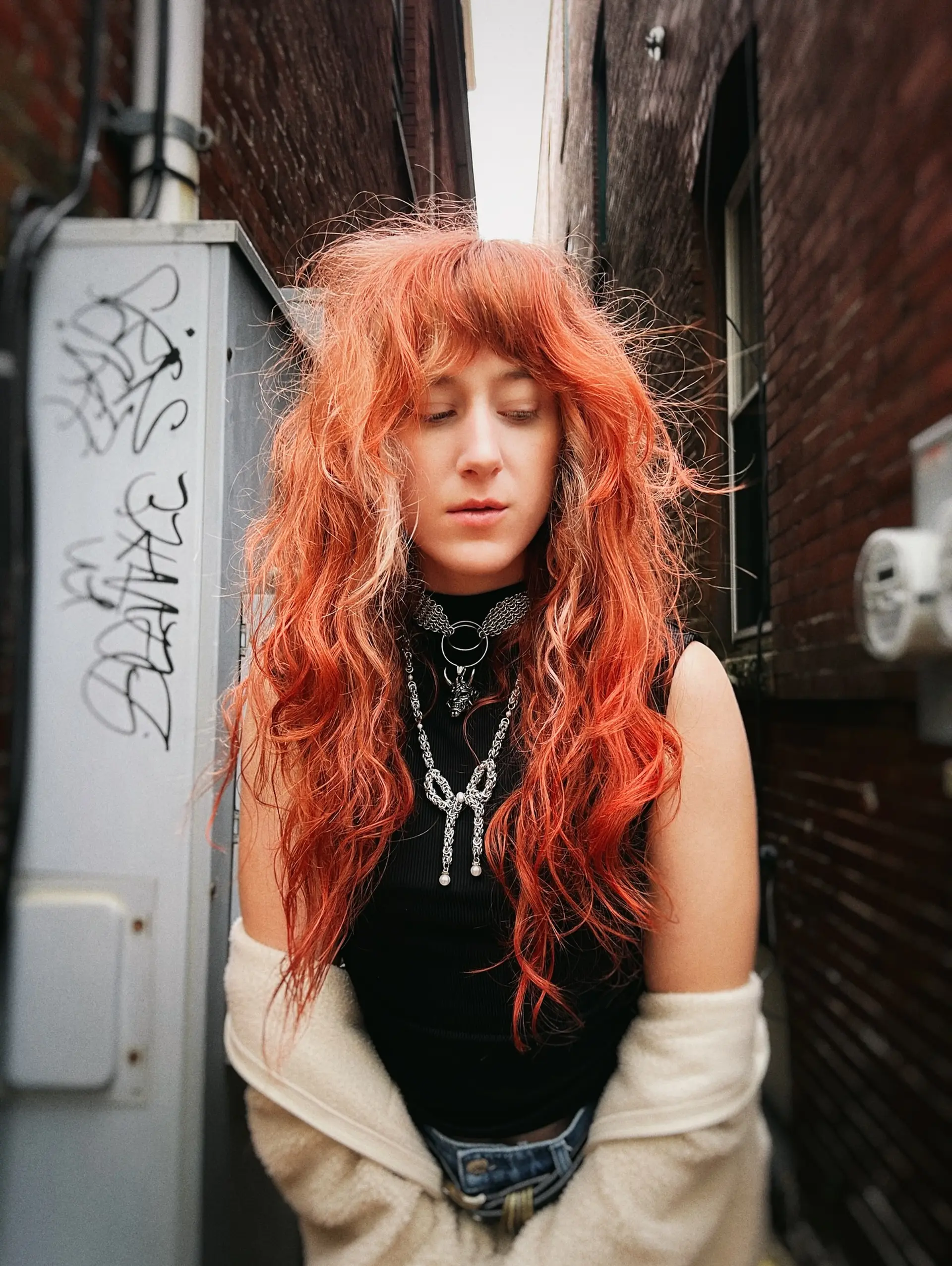 Vibrant copper long shag haircut featuring textured layers, messy voluminous waves, and face-framing fringe. 1