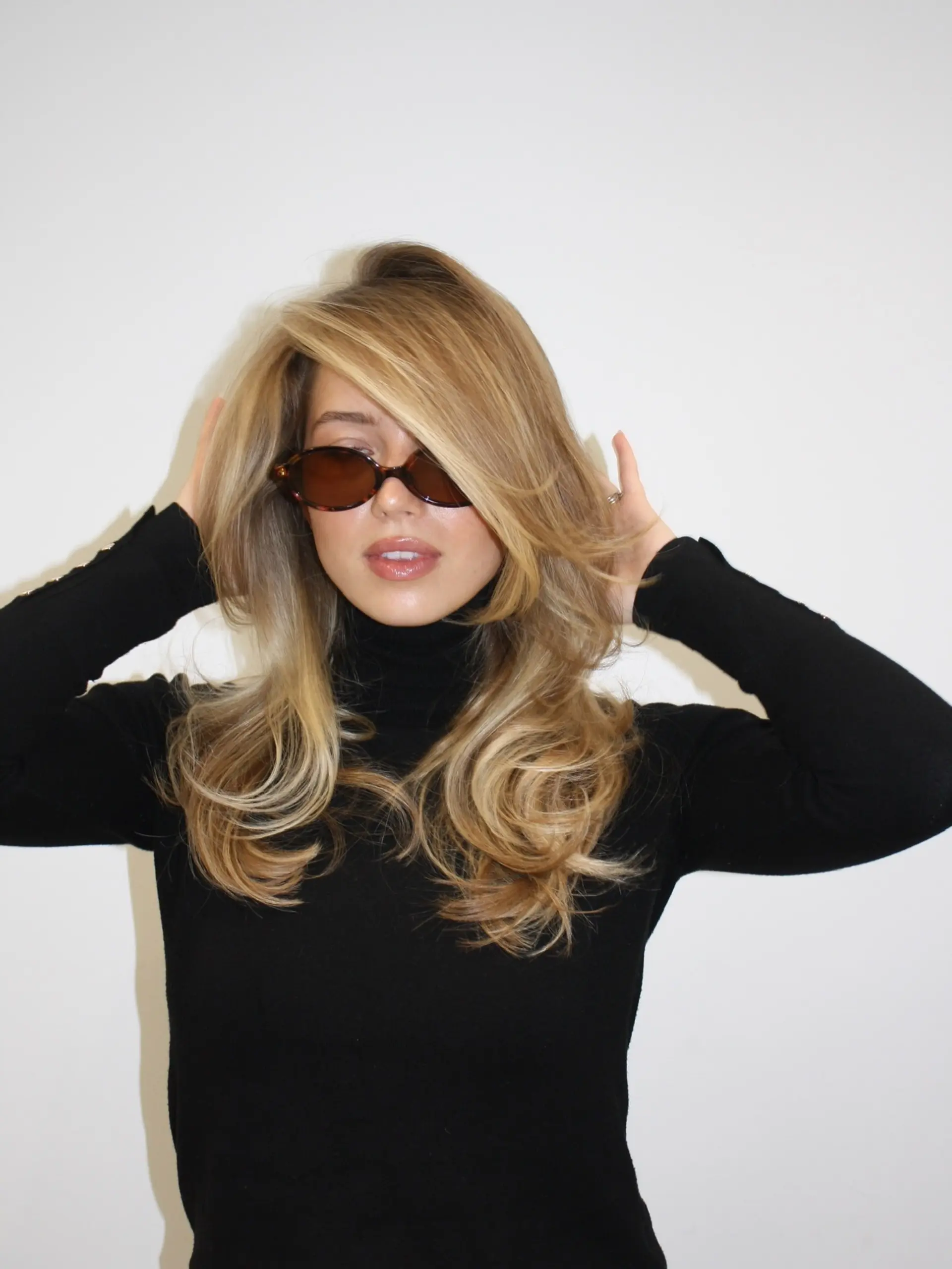 A voluminous 90s-inspired bouncy blowout with sweeping face-framing layers and dimensional golden blonde highlights. 1