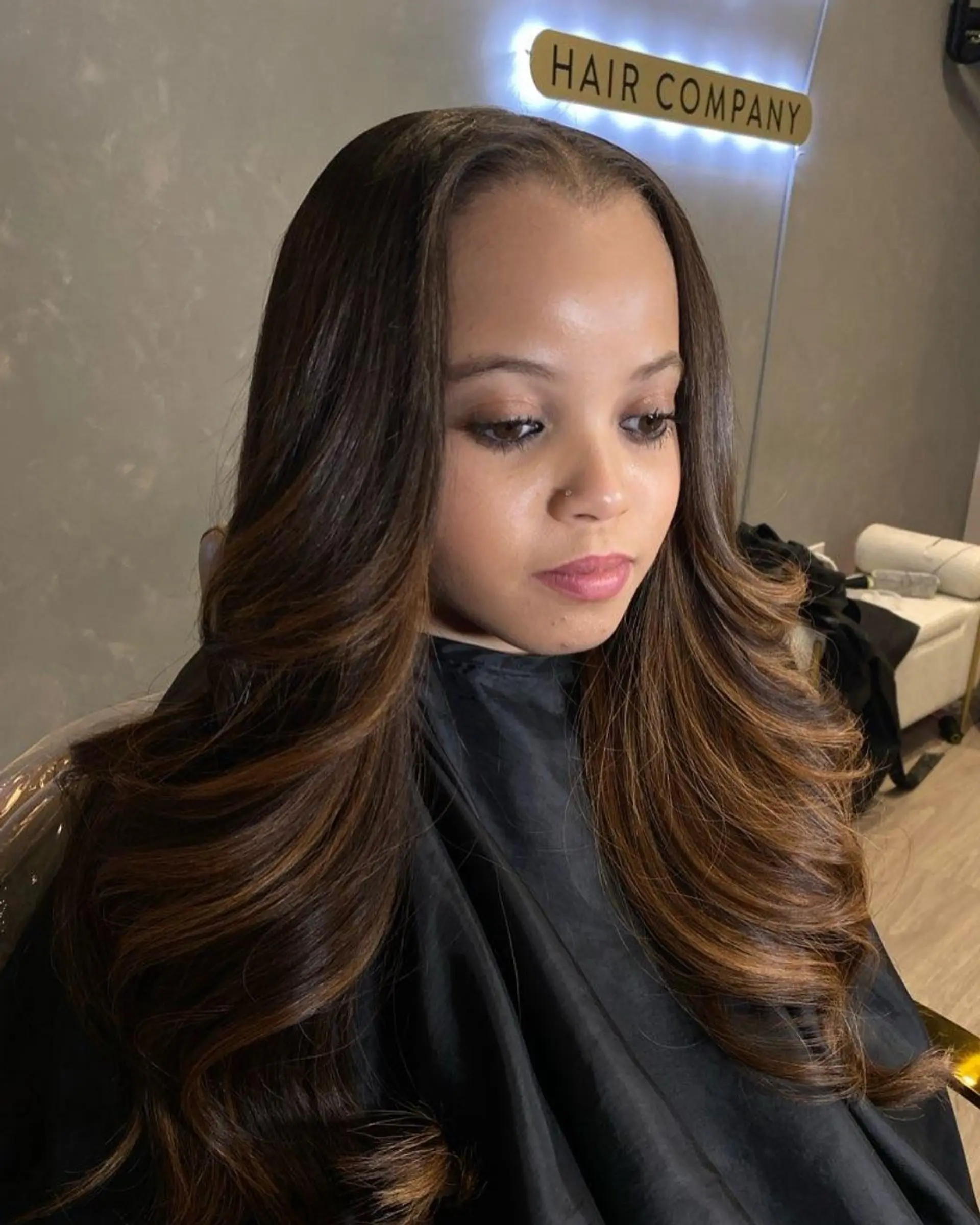 A long, wavy balayage hairstyle with bronze and auburn highlights. 1