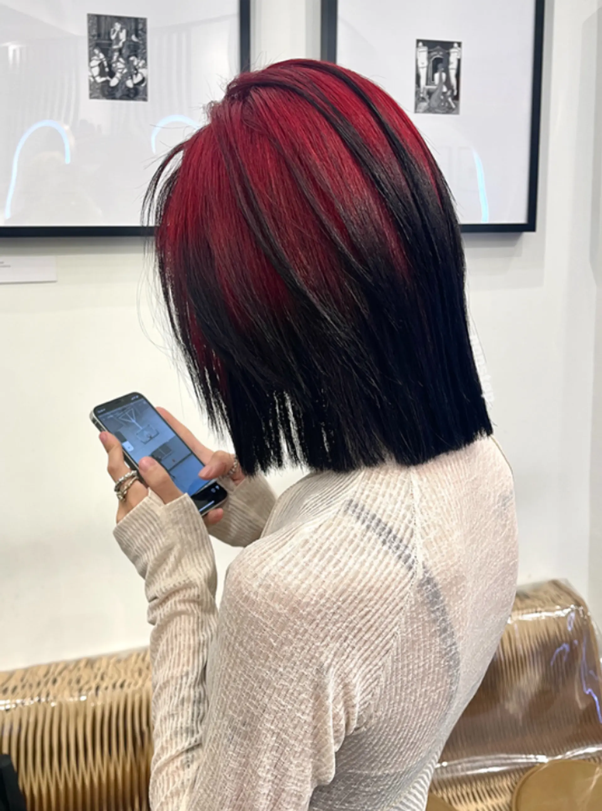 A medium-length straight bob with vibrant crimson red hues on the top layers, transitioning into deep black on the lower layers, cut with precise, edgy layers for a bold, modern look. 1